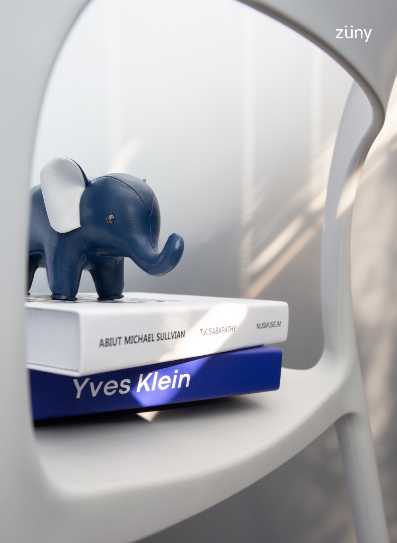 Zuny Buchstütze Classic Elefant in Mitternachtsblau und Weiß auf zwei Büchern, Nahaufnahme.