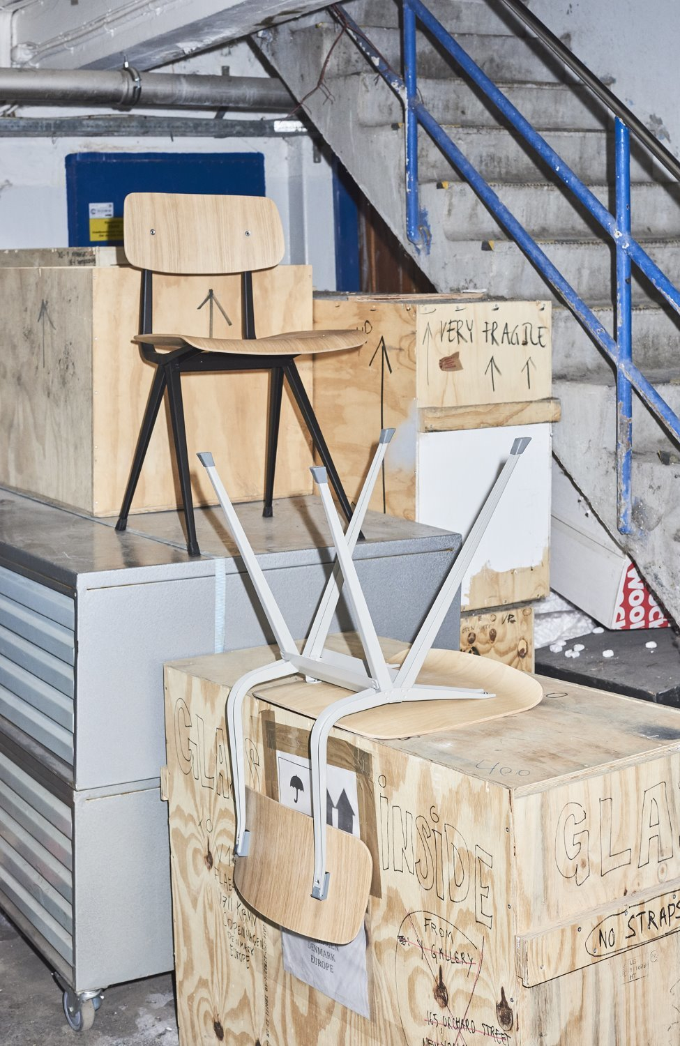 Hay Result Chair Stuhl aus Holz und Stahl, zwei Stühle gestapelt auf Holzkisten.