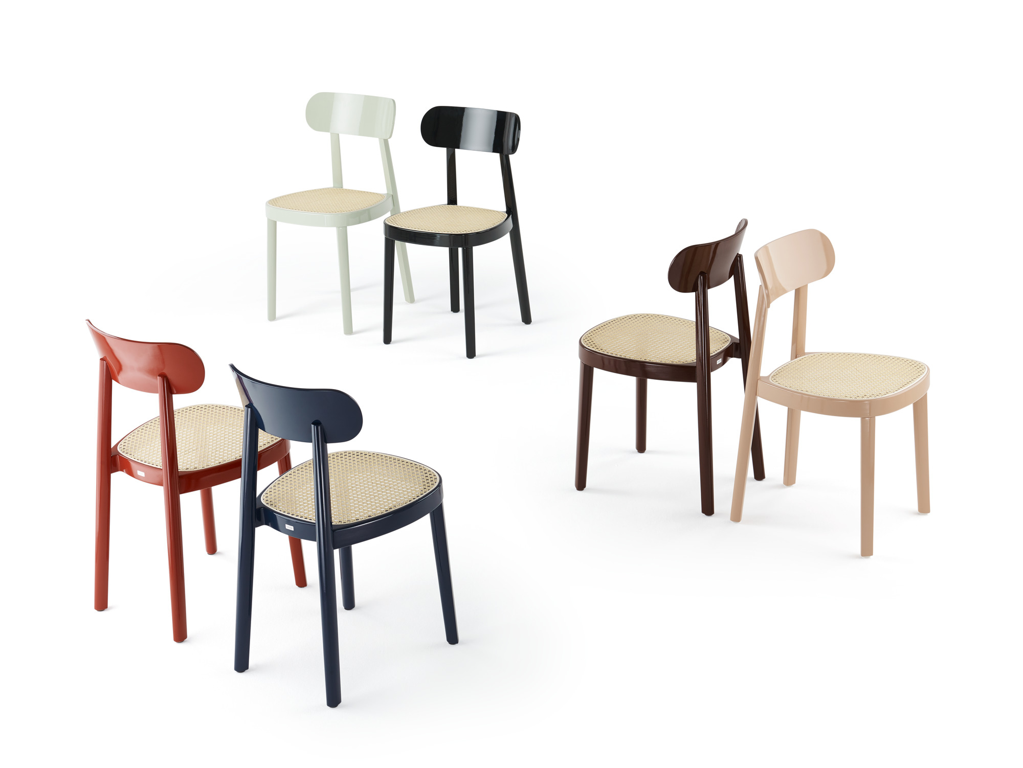 Fünf Thonet 118 Holzstühle in verschiedenen Farben mit Wiener Geflecht auf weißem Hintergrund.