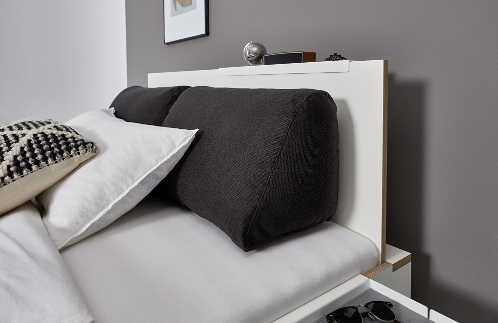Flai Einzelbett von Müller Möbelwerkstätten mit Kissen und Ablage im modernen Schlafzimmer.