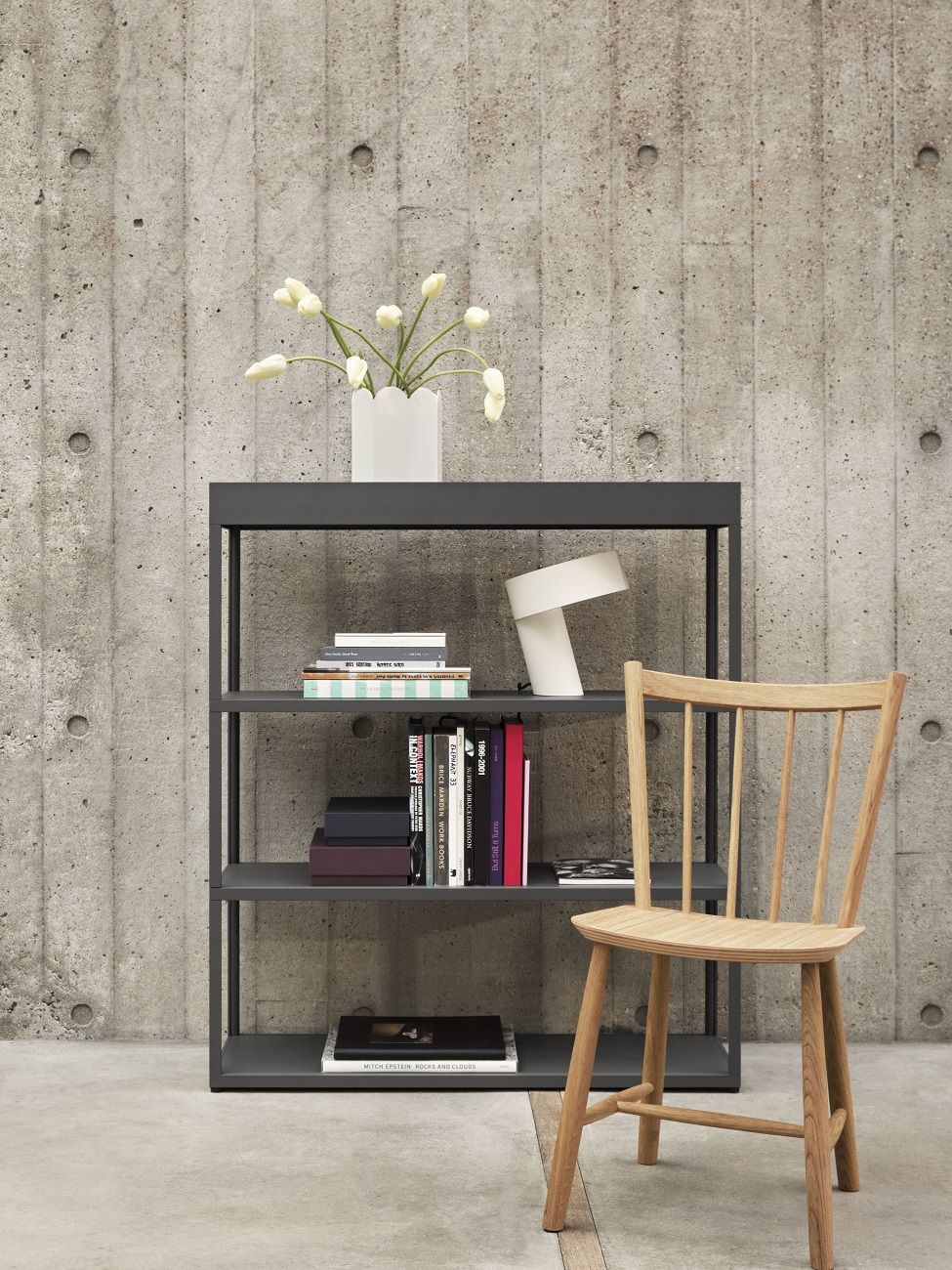 J41 Stuhl von Hay aus Eiche vor Bücherregal mit Betonwand im Hintergrund.