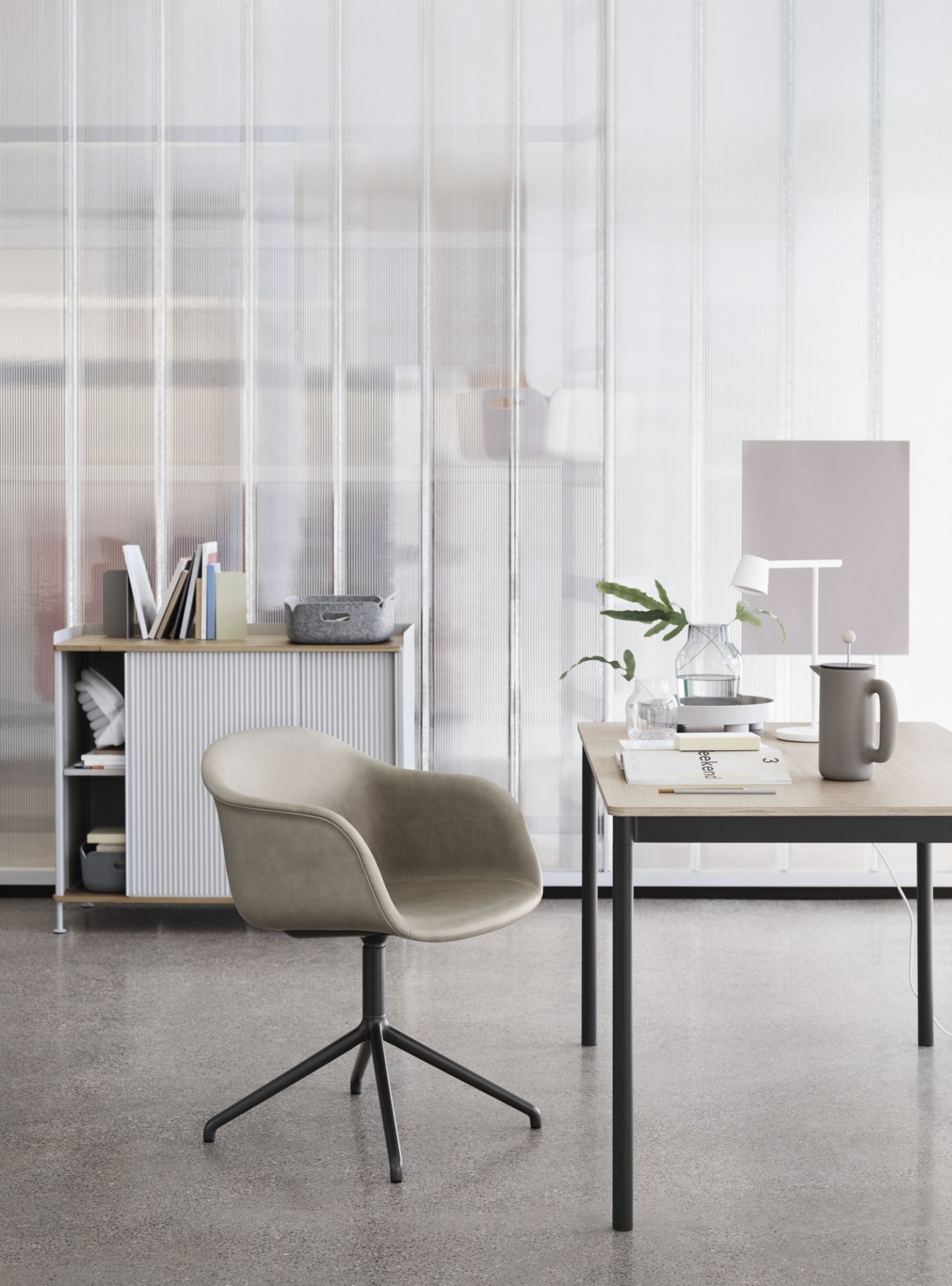 Beiger Fiber Armchair mit Drehfuß von Muuto, Bürostuhl vor Schreibtisch und Regal.