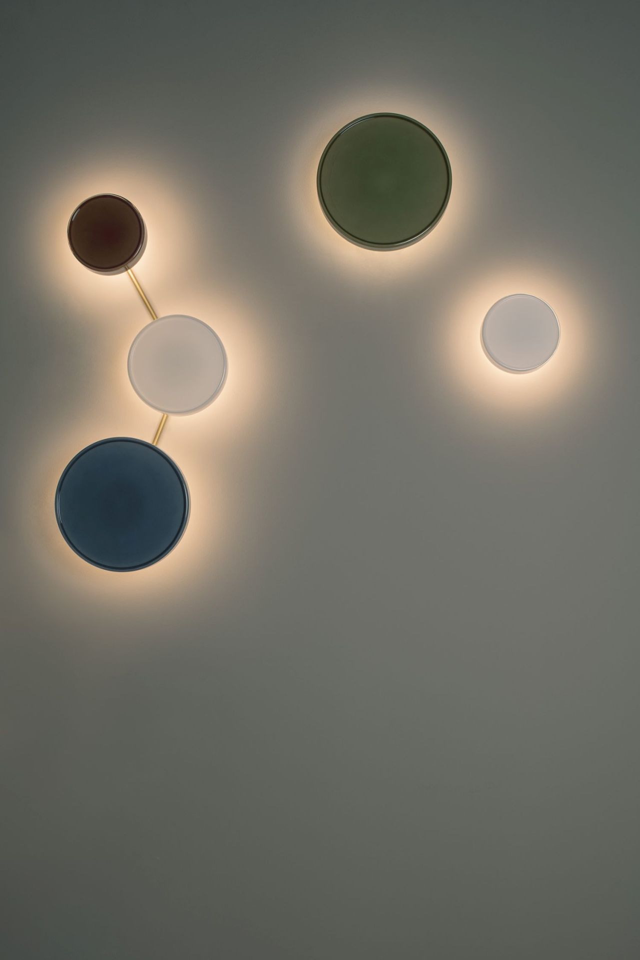 Caramel Wandleuchte mit Verbindungsstab in Gold: Moderne Wandlampe mit farbigen, runden Leuchten.
