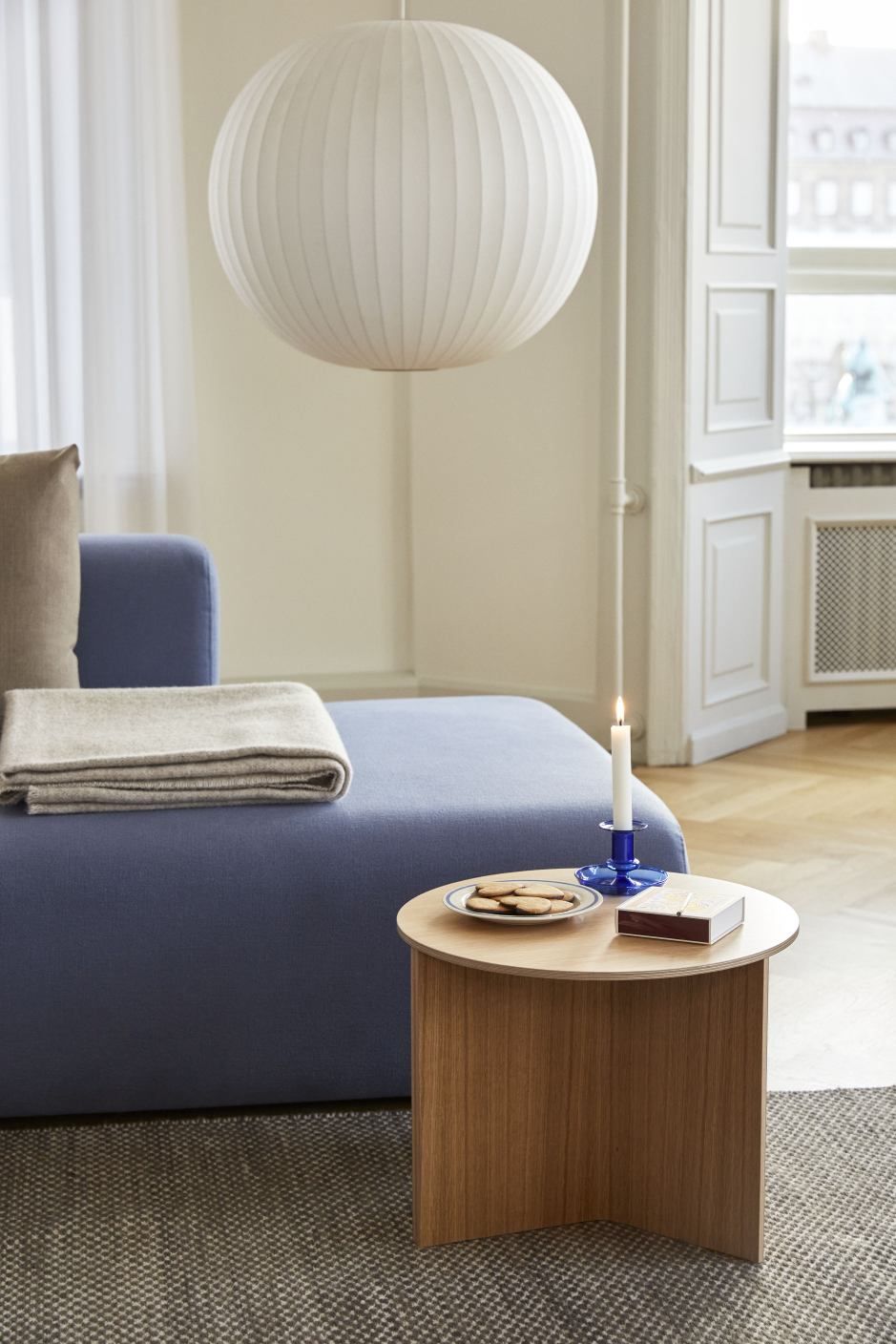 Mags Sofa Ecke mit Hallingdal Stoff in blau, kombiniert mit Holztisch und Lampe.