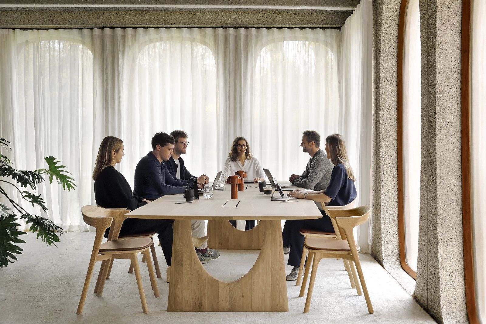 Besprechungsszene mit sechs Personen am Geometric Meetingtisch von Ethnicraft, Eiche lackiert, mit integrierten Kabelboxen.