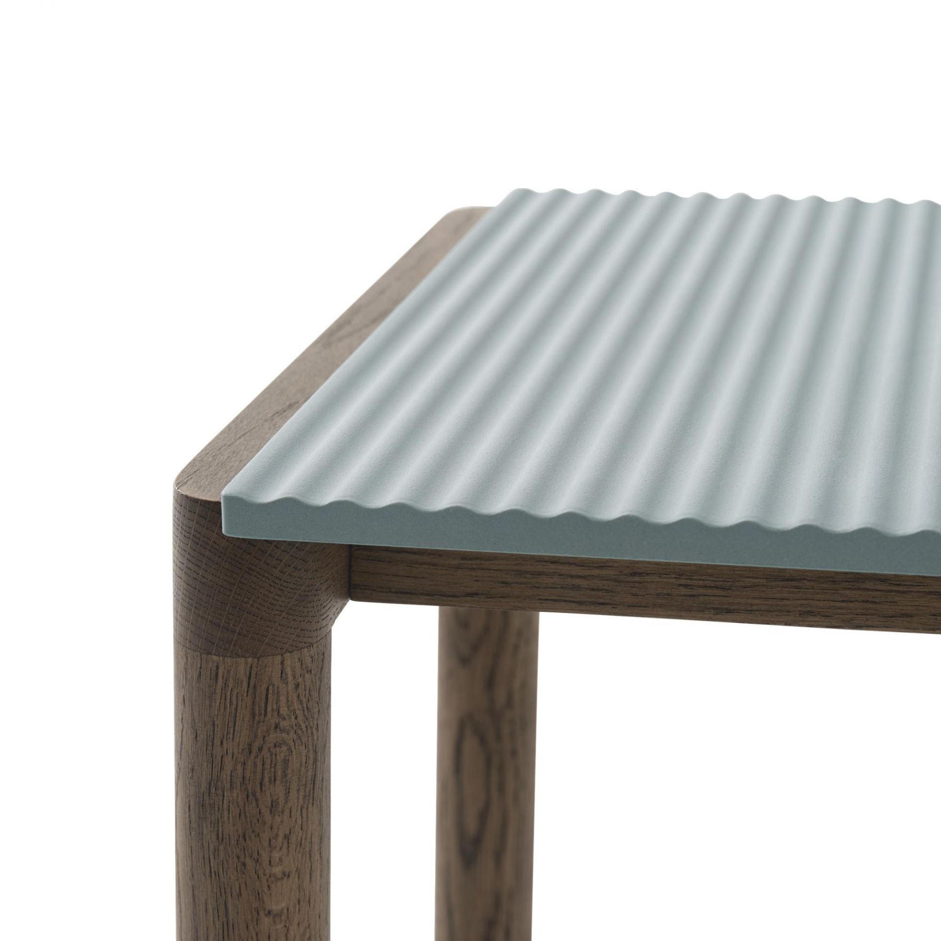 Detailaufnahme des Muuto Couple Coffee Table: Couchtisch mit geriffelter, hellblauer Tischplatte und dunklem Holzgestell.