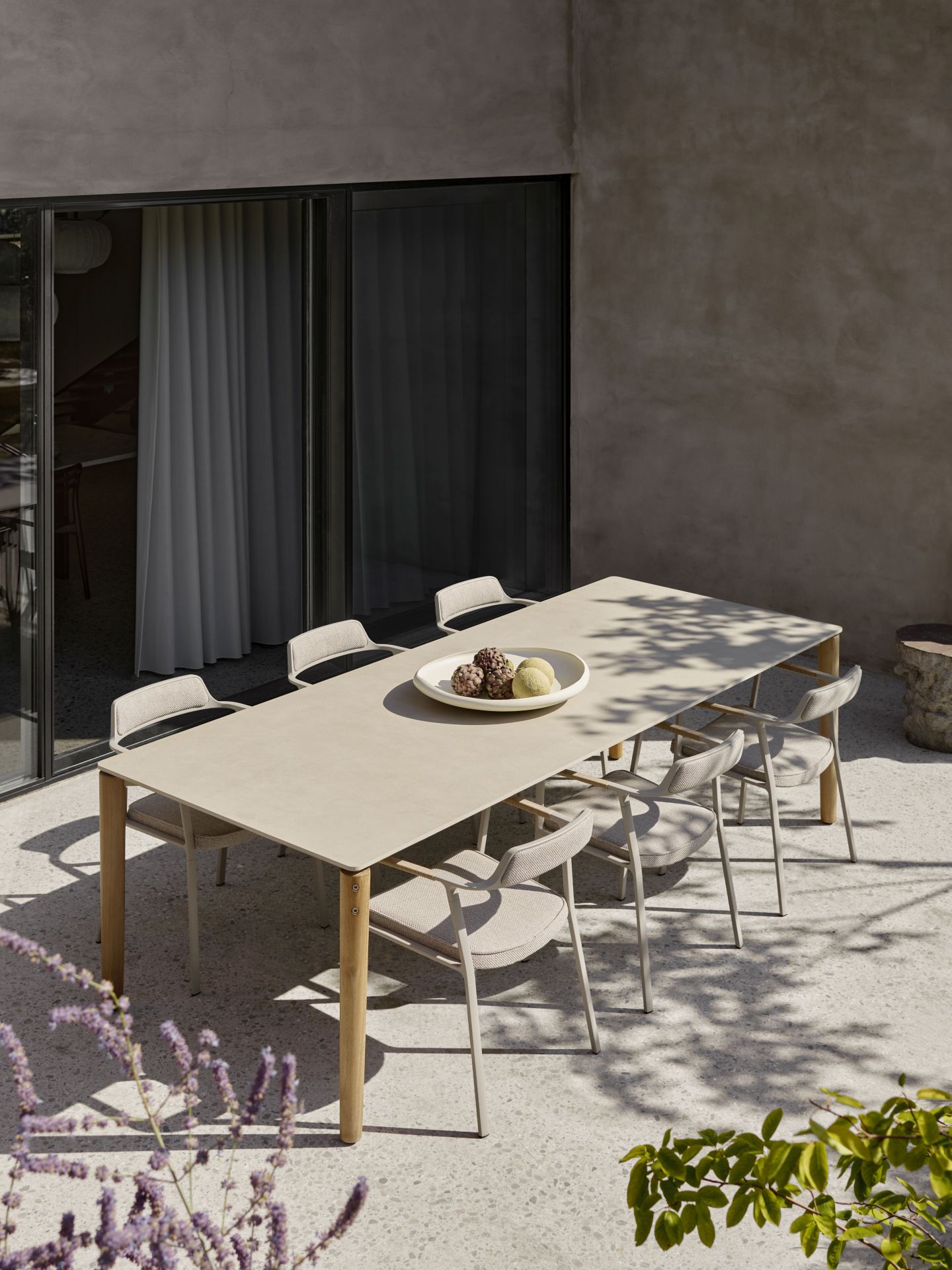 Vipp Open-Air Outdoor Tisch mit sechs Stühlen auf einer Terrasse, gedeckt mit Obstschale.