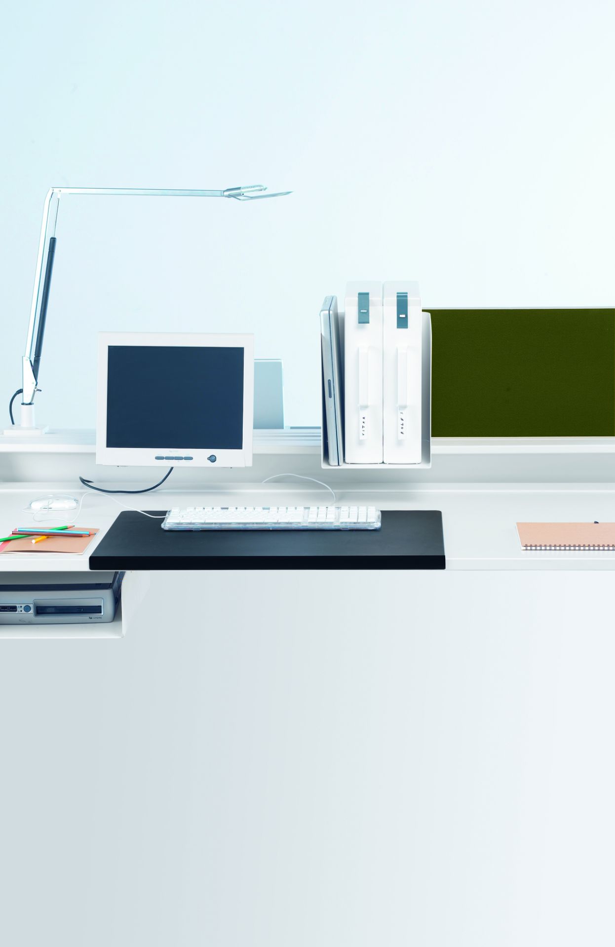 Schreibtisch mit Vitra Schreibtischunterlage in Mauve Grau, Tastatur, Monitor und Büromaterial für einen organisierten Arbeitsplatz.