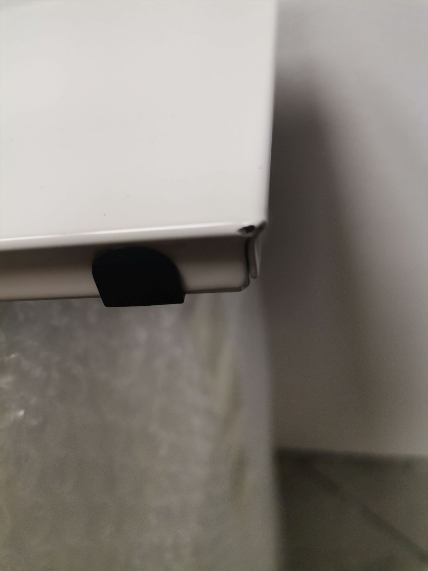 Detailaufnahme eines beschädigten USM Haller Möbelteils, ein Mängelexemplar mit schwarzer Abdeckung und Lackschaden.