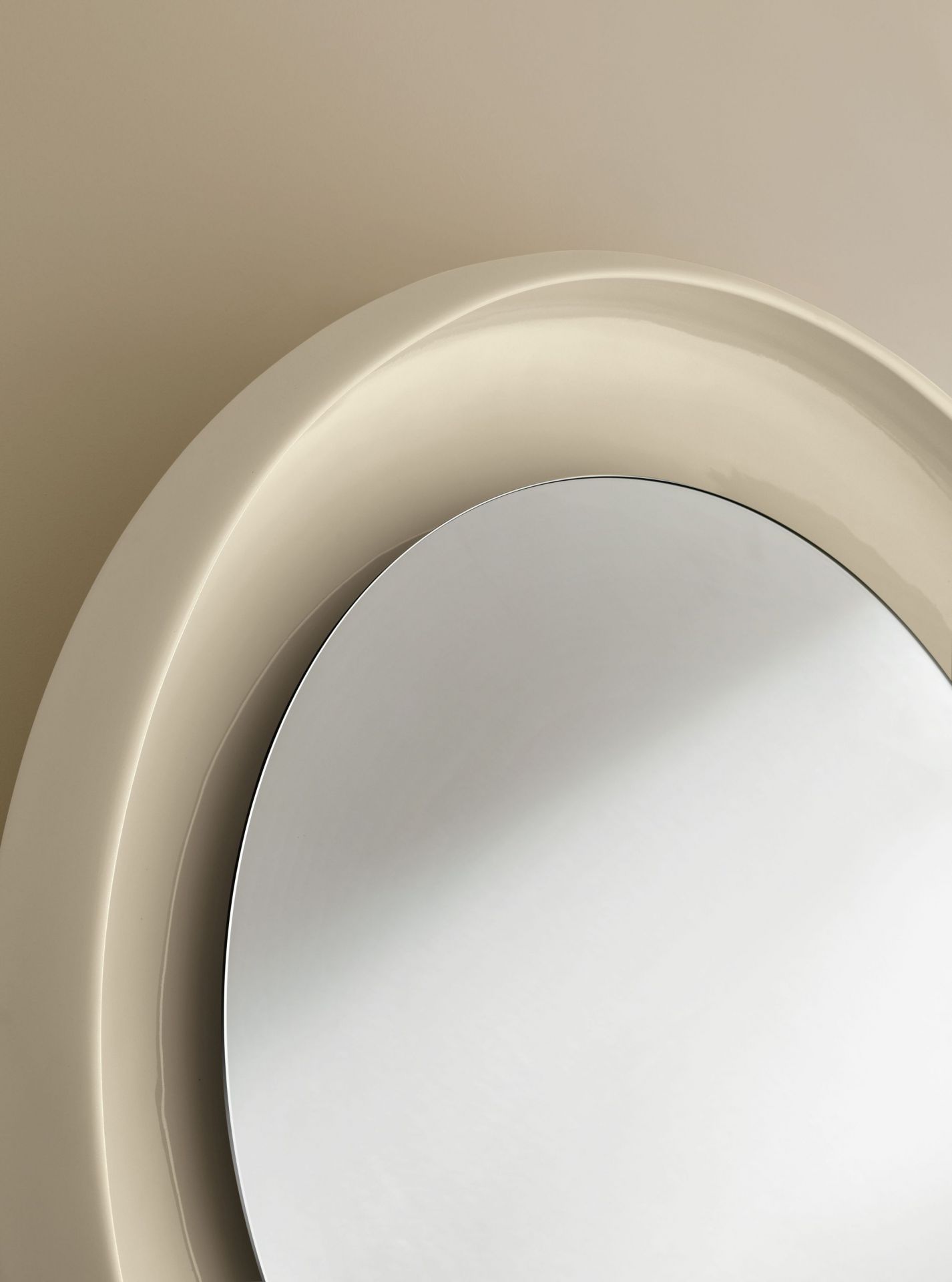 Detailaufnahme des Coque Spiegels von Miniforms mit beigem Keramikrahmen und runder Spiegelfläche.