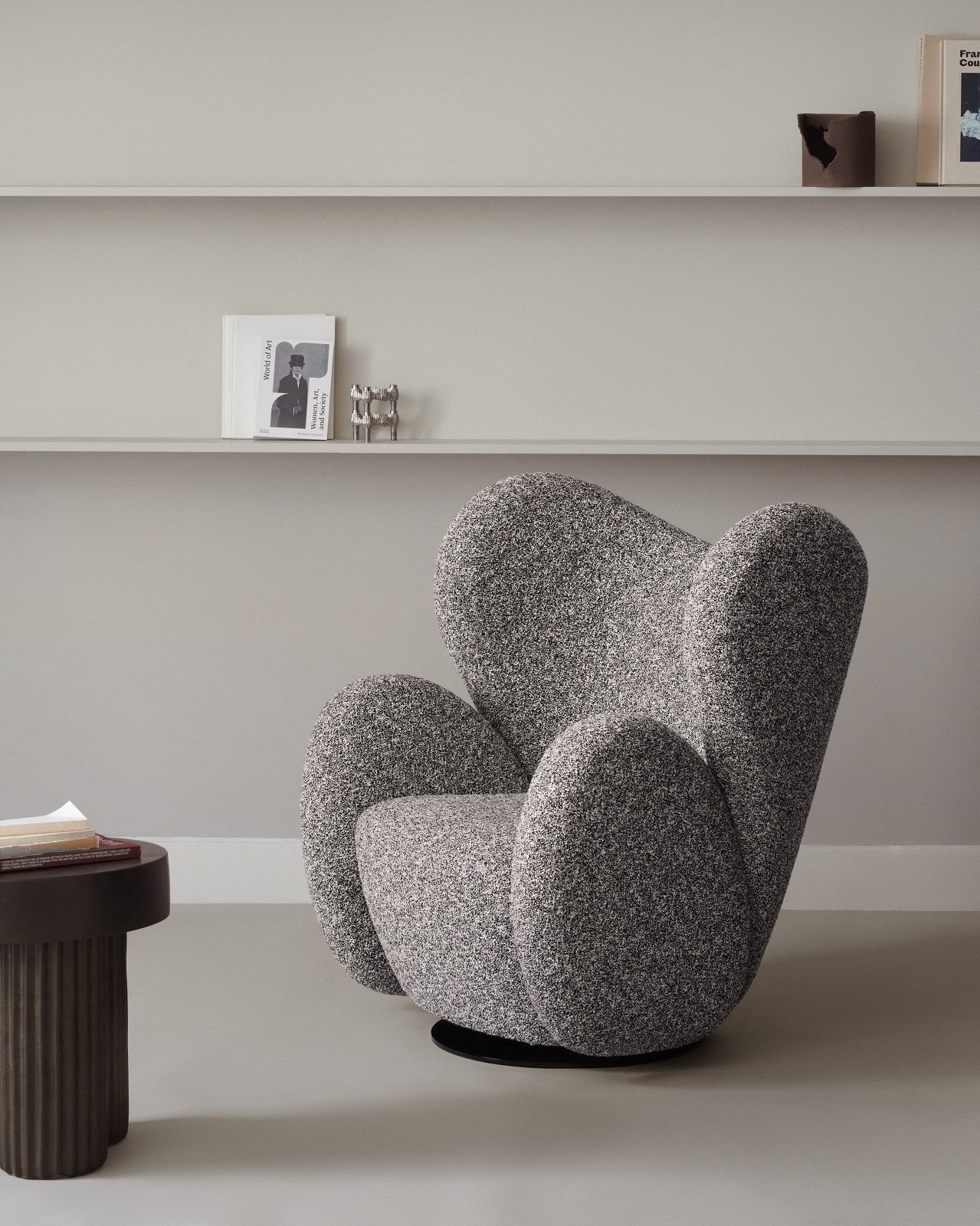 Gear Tall Side Table von Norr11 aus dunklem Holz neben einem Sessel in einem minimalistischen Raum.