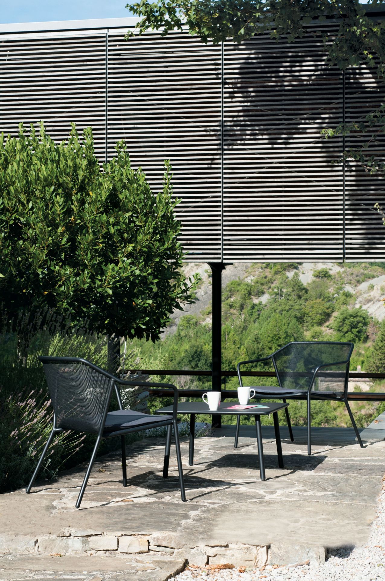 Emu Darwin Coffee Table Beistelltisch auf Terrasse mit zwei Stühlen und Kaffeetassen.