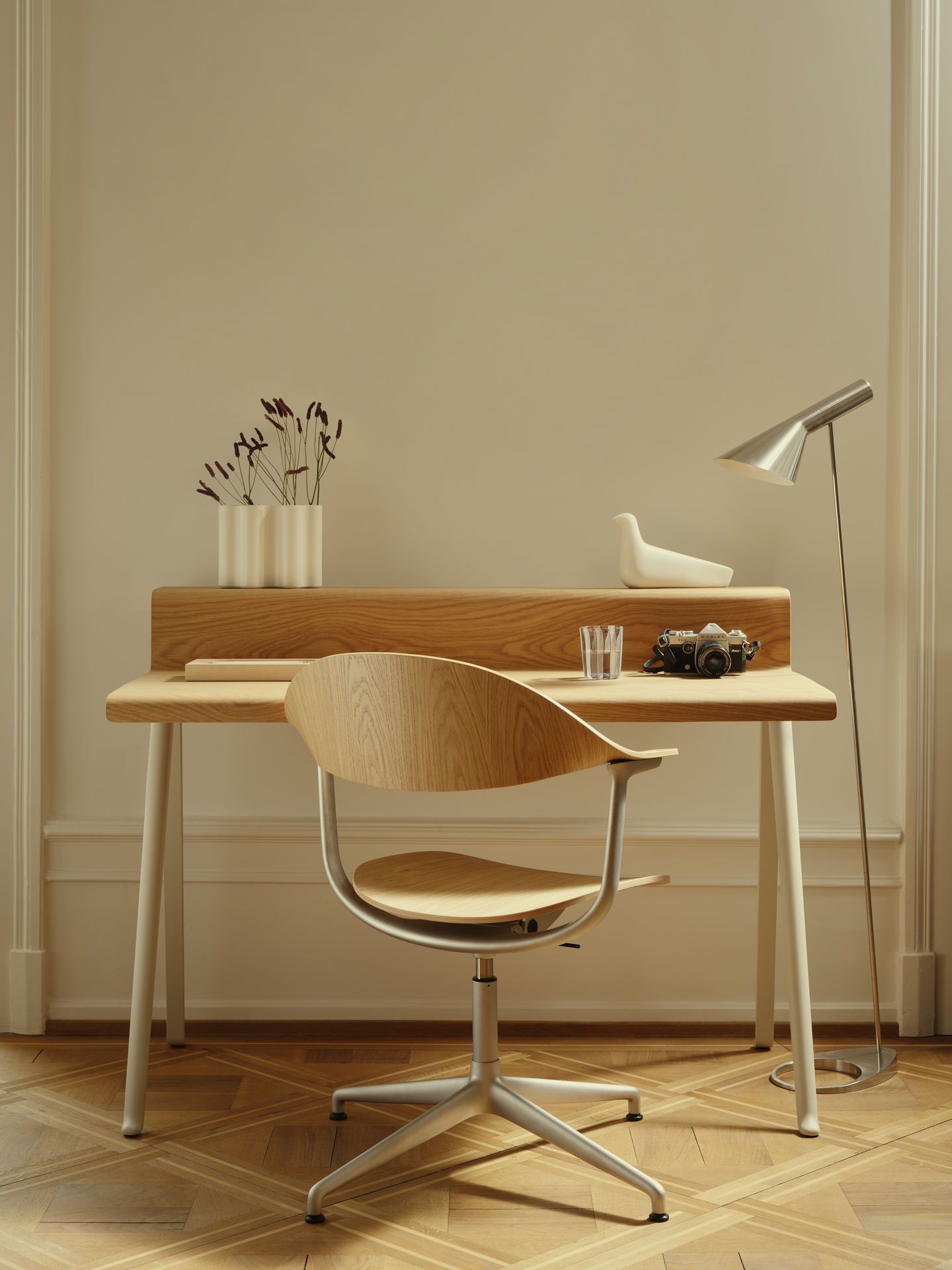 Mynt Bürodrehstuhl von Vitra aus hellem Schichtholz am Schreibtisch mit Kamera und Lampe.