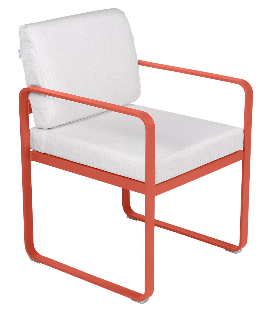 Bellevie Sessel von Fermob für den Außenbereich, orangefarbenes Metallgestell mit weißen Sitz- und Rückenkissen.