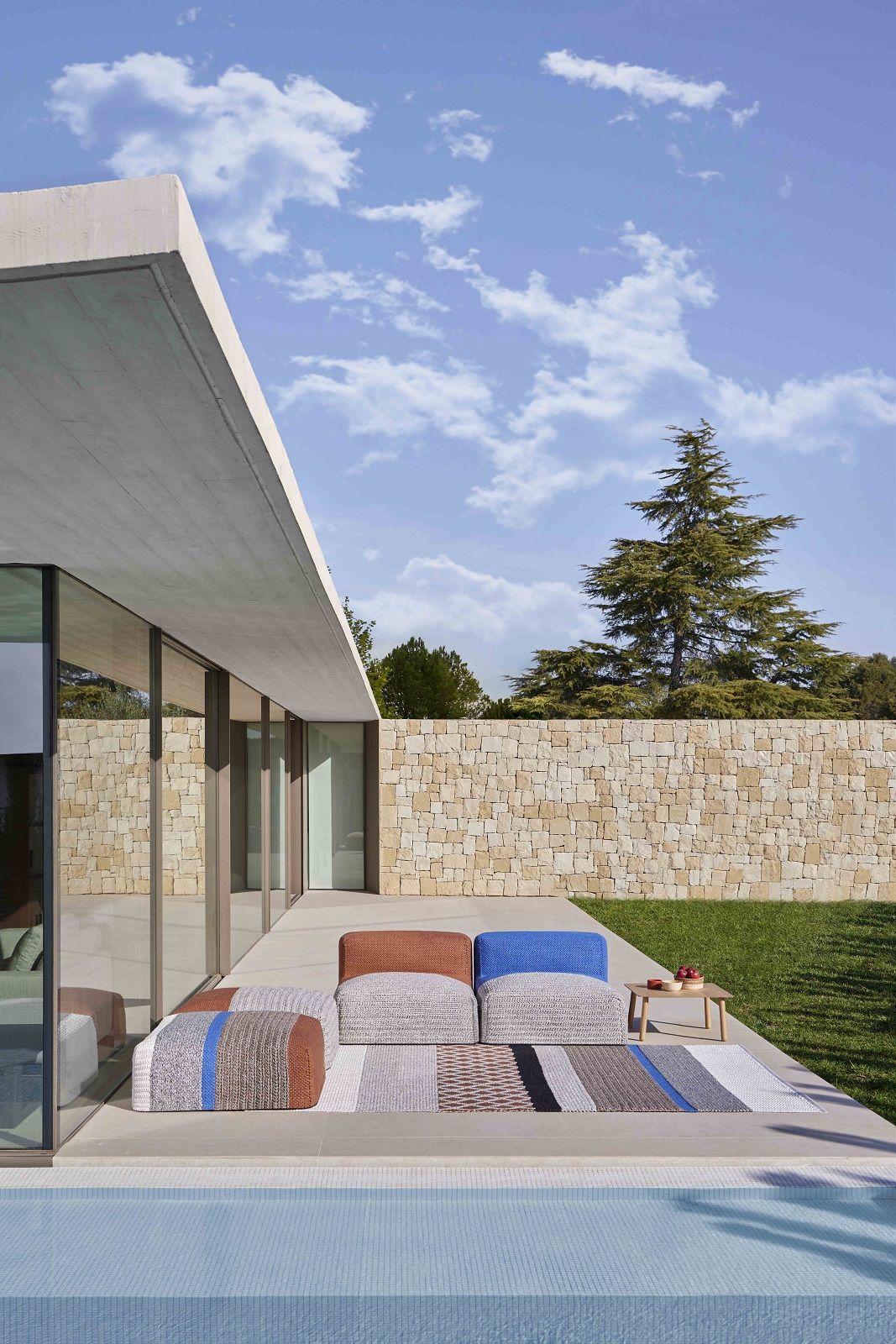 Mangas Outdoor Modules Sessel Gan auf Terrasse mit Pool und Garten, moderne Outdoor-Möbel.