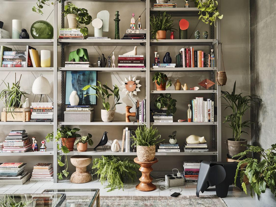 Regal mit Deko-Objekten, darunter eine Girard Bird Skulptur, Bücher, Pflanzen und andere Design-Accessoires.