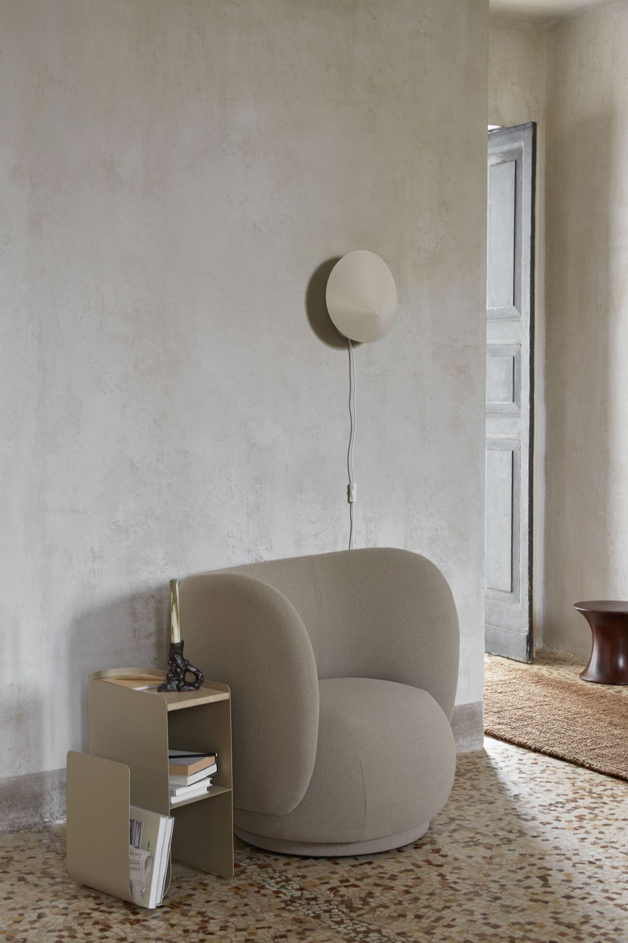 Beige Arum Wandleuchte von Ferm Living über Sessel in stilvollem Interieur. Moderne Innenraumbeleuchtung.