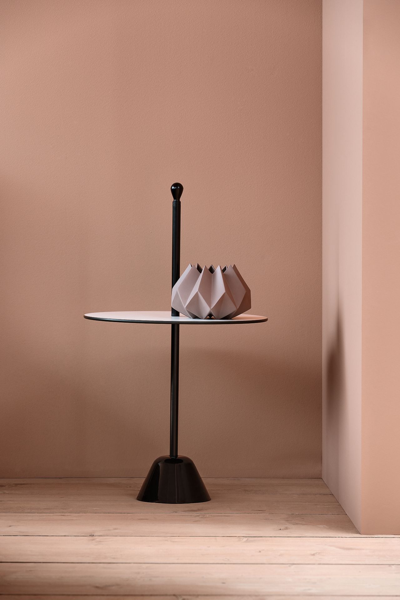 Schwarzer Servomuto Beistelltisch von Zanotta mit Vase auf weißer Tischplatte vor rosa Wand.