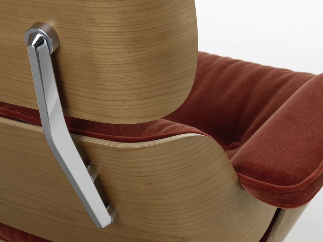 Detailaufnahme: Eames Lounge Chair Sessel mit Holzrahmen und rotem Samtbezug, Designklassiker für Wohnzimmer.