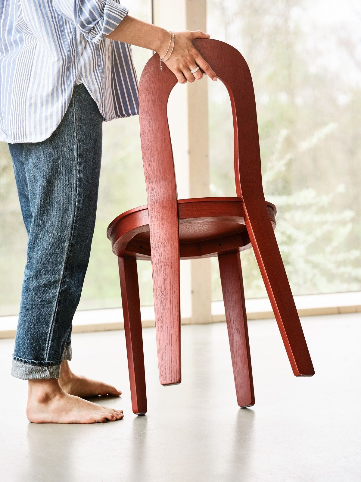 Olivia Chair Holzstuhl von Design House Stockholm, Detailaufnahme einer Person, die den Stuhl anhebt.