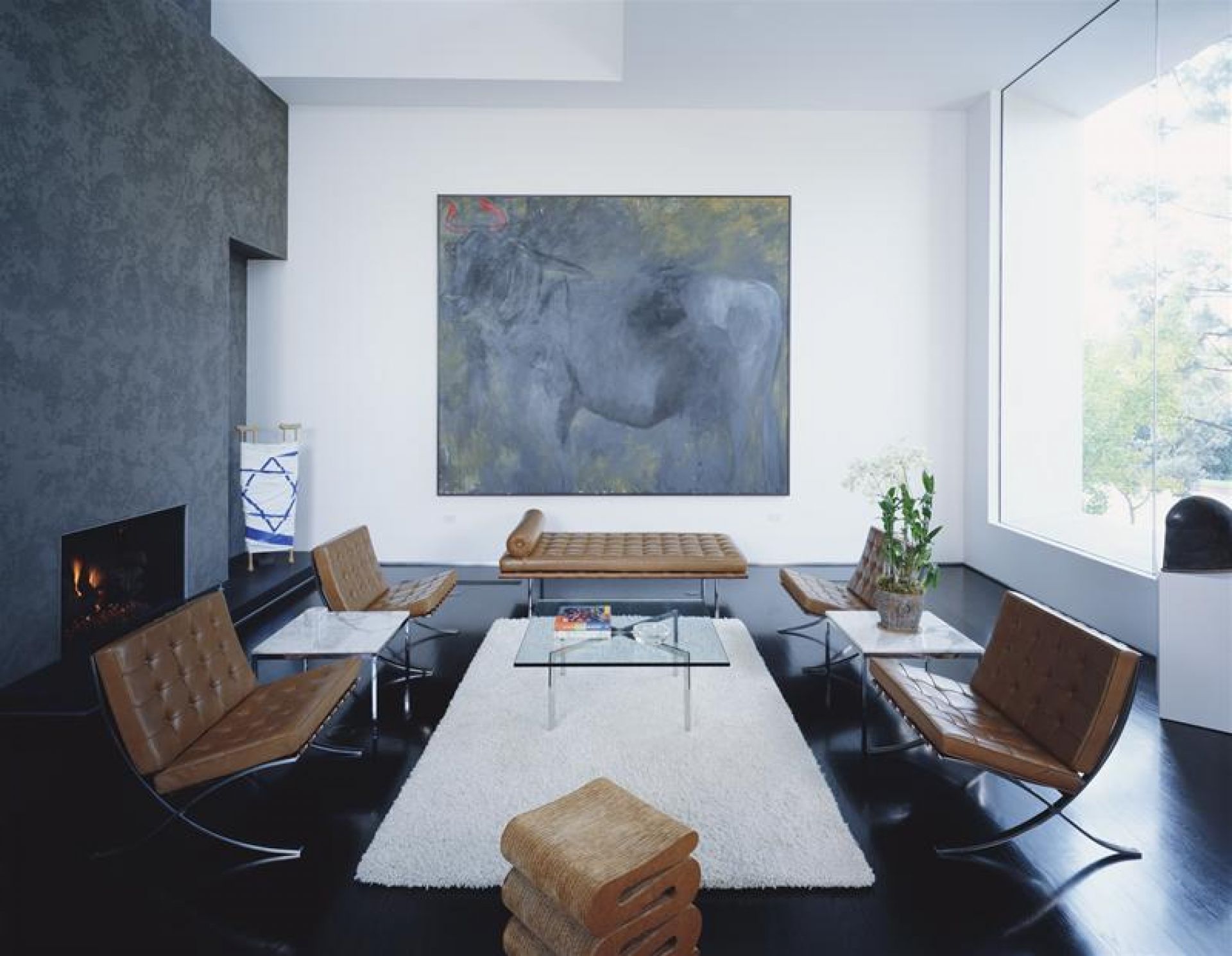 Barcelona Couchtisch aus Kristallglas von Knoll International in einem modernen Wohnzimmer mit Ledersesseln.
