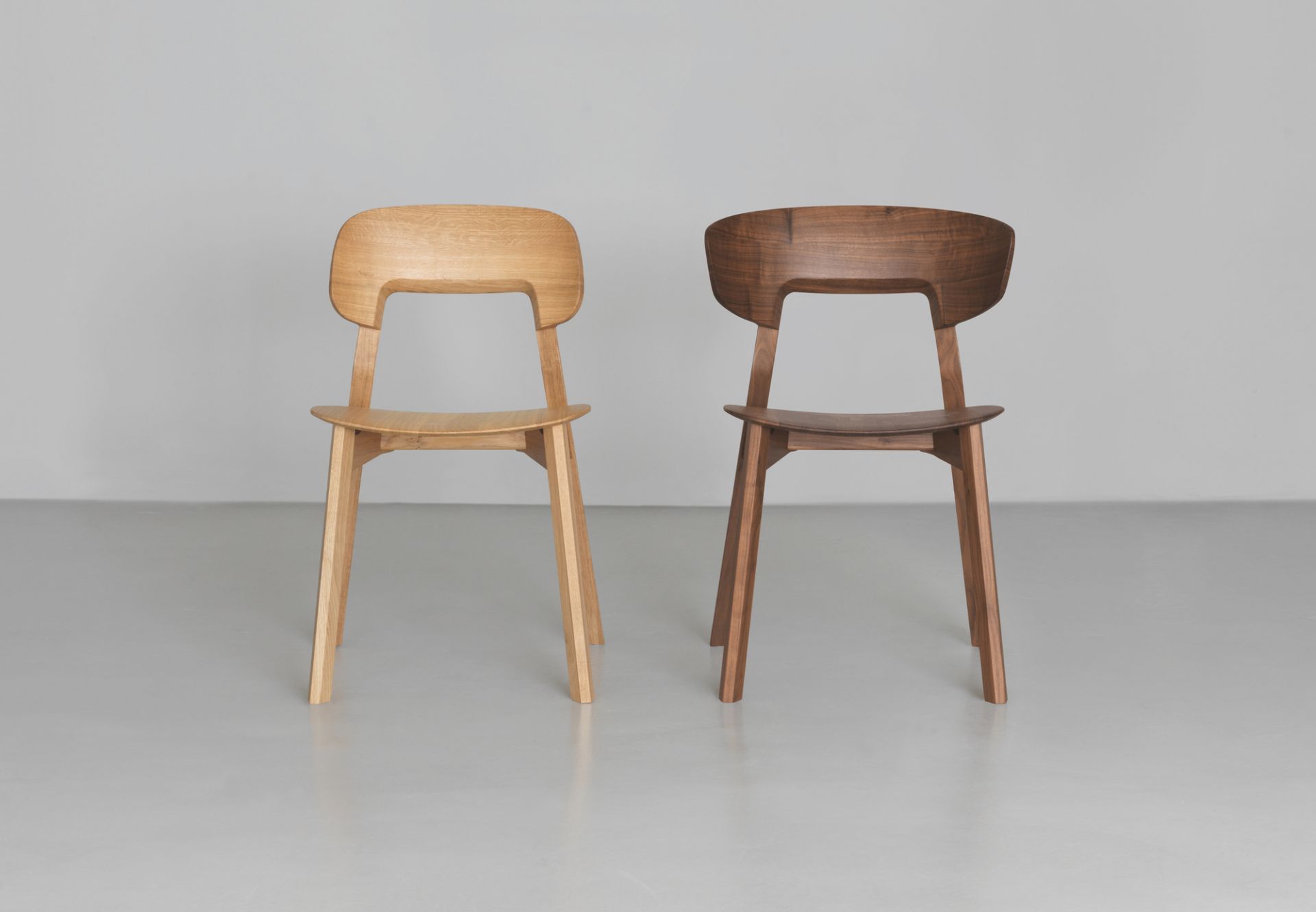 Zwei Nonoto Holzstühle, einer aus hellem, einer aus dunklem Holz, modernes Design.