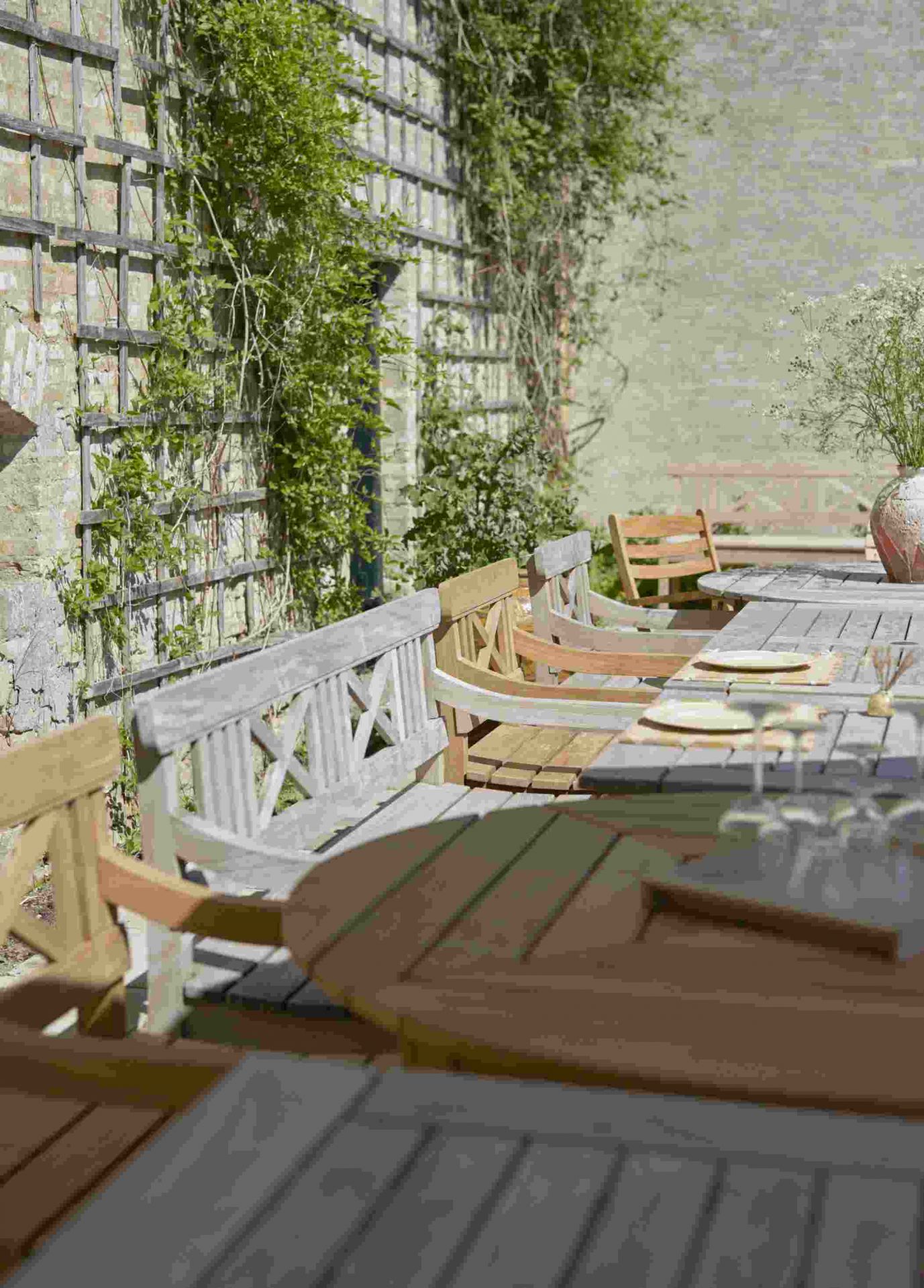 Drachmann Tisch von Skagerak by Fritz Hansen: Runder Gartentisch aus Holz mit passenden Gartenbänken.
