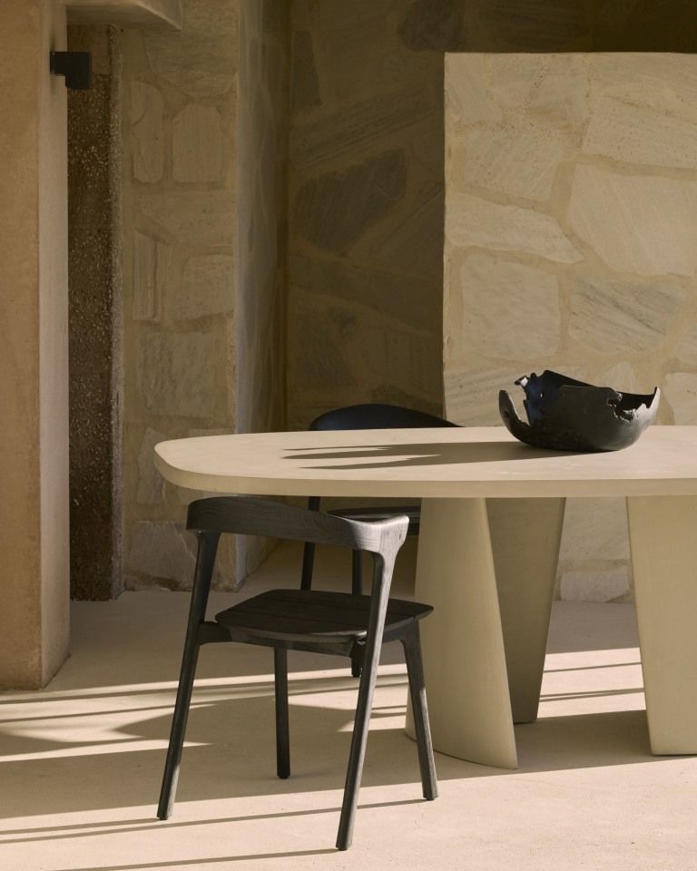 Canyon Outdoor Esstisch von Ethnicraft aus Beton mit Stuhl und Dekoschale im Innenbereich.