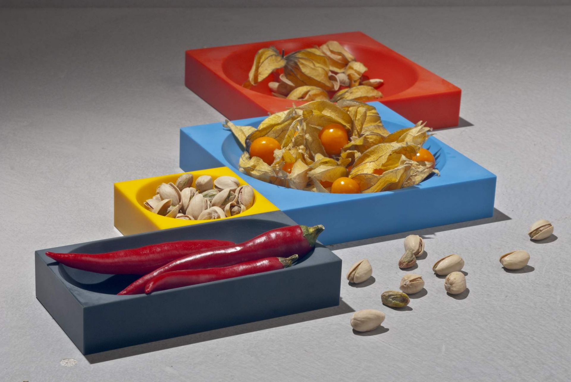 Modul 1 Magnetic Bowl Schale Farmer: Farbige Schalen mit Physalis, Pistazien und roten Chilis.