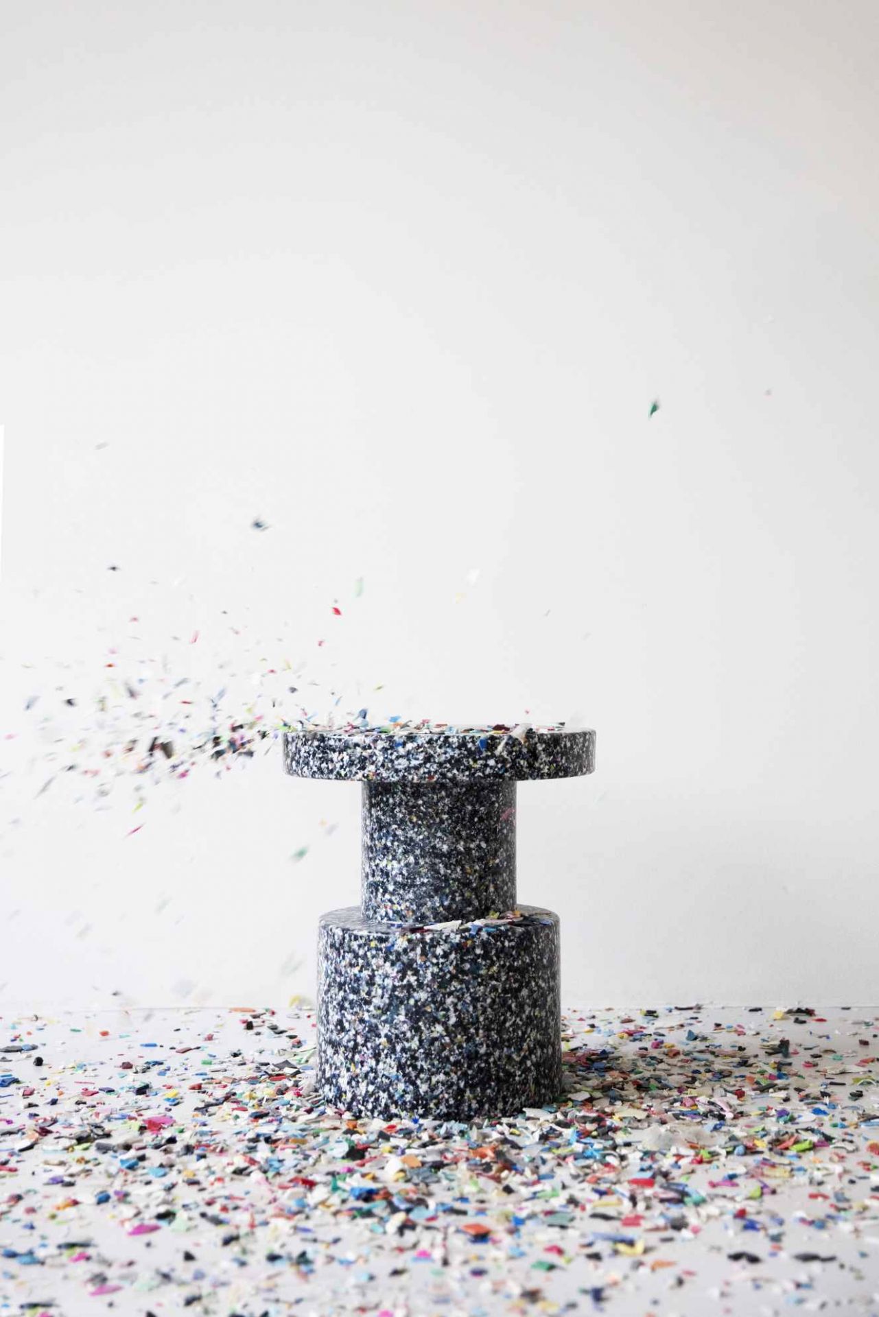 Normann Copenhagen Bit Stool Hocker aus recyceltem Kunststoff mit Konfetti-Effekt vor weißem Hintergrund.