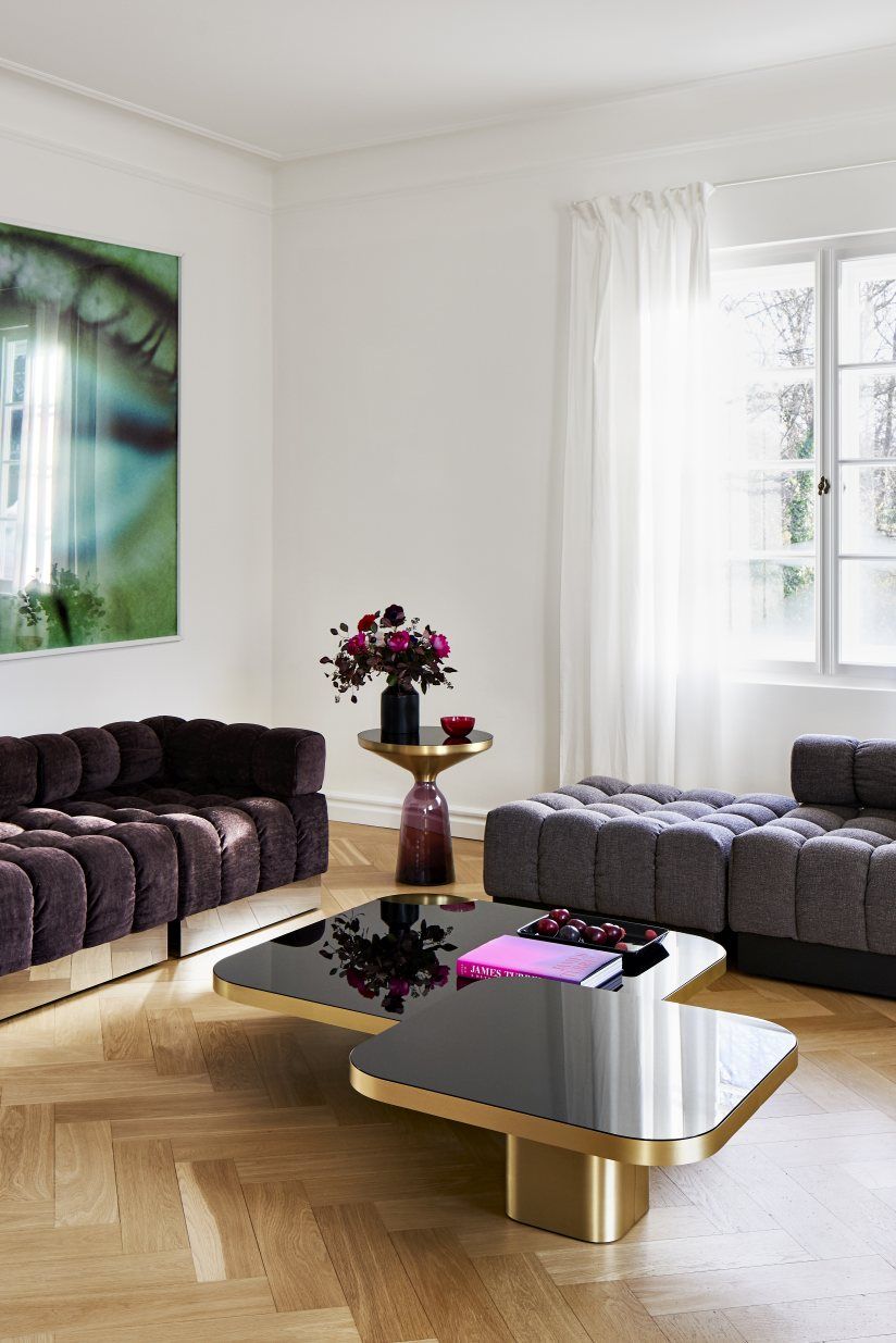 Moderner Wohnraum mit ClassiCon Bow Coffee Table Couchtisch in Schwarz und Gold.