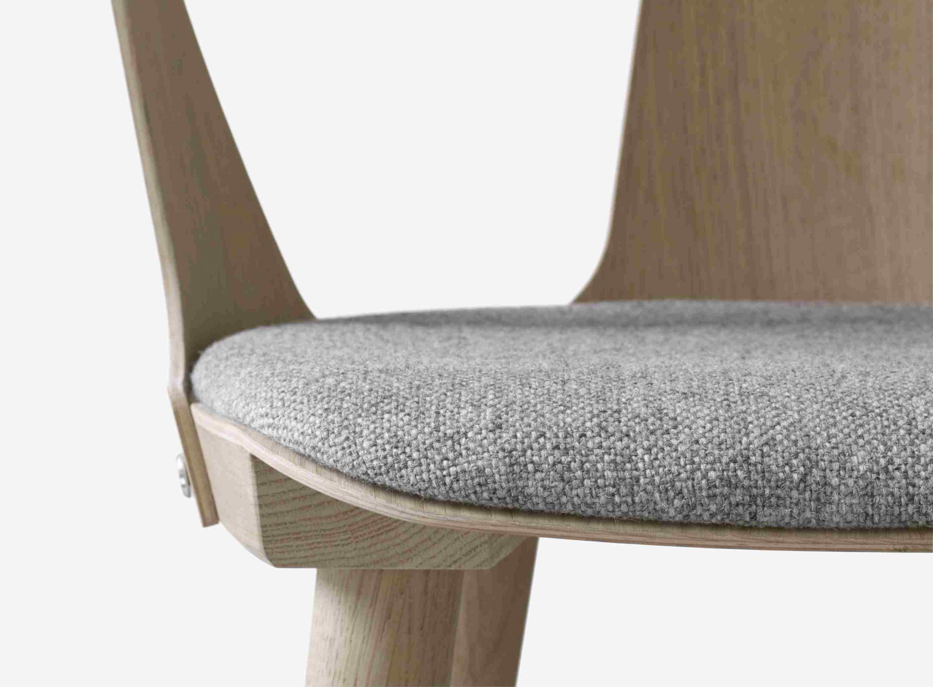Detailaufnahme des In Between Armchair Armlehnenstuhls von AndTradition mit grauem Sitzpolster und hellem Holzrahmen.