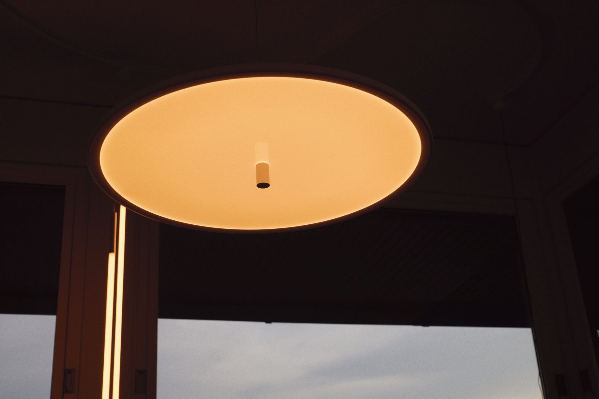 Nahaufnahme der runden My Disc Hängeleuchte von Flos, warmes Licht, modernes Design.