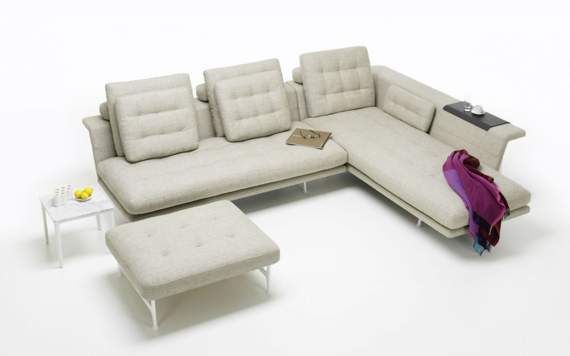 Helle Grand Vitra Sofa-Ecke mit Chaiselongue, passendem Hocker und Beistelltisch auf weißem Hintergrund.