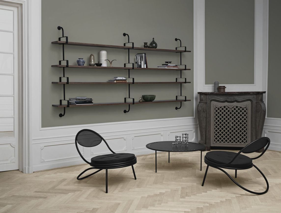 Wohnzimmer mit Gubi Regal, Modell Démon Shelf, dunkles Holz und schwarze Halterungen.