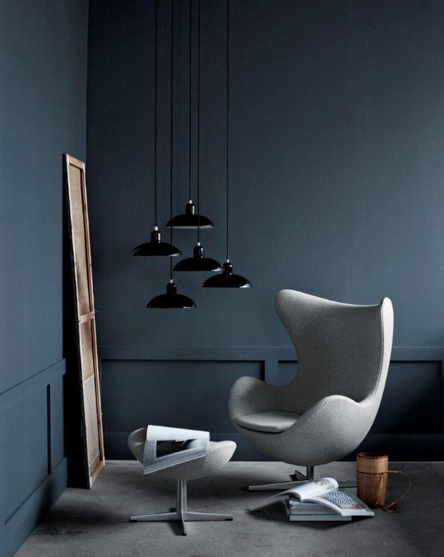 Grauer Egg Chair Sessel mit Hocker von Fritz Hansen in stilvollem, dunklem Ambiente.