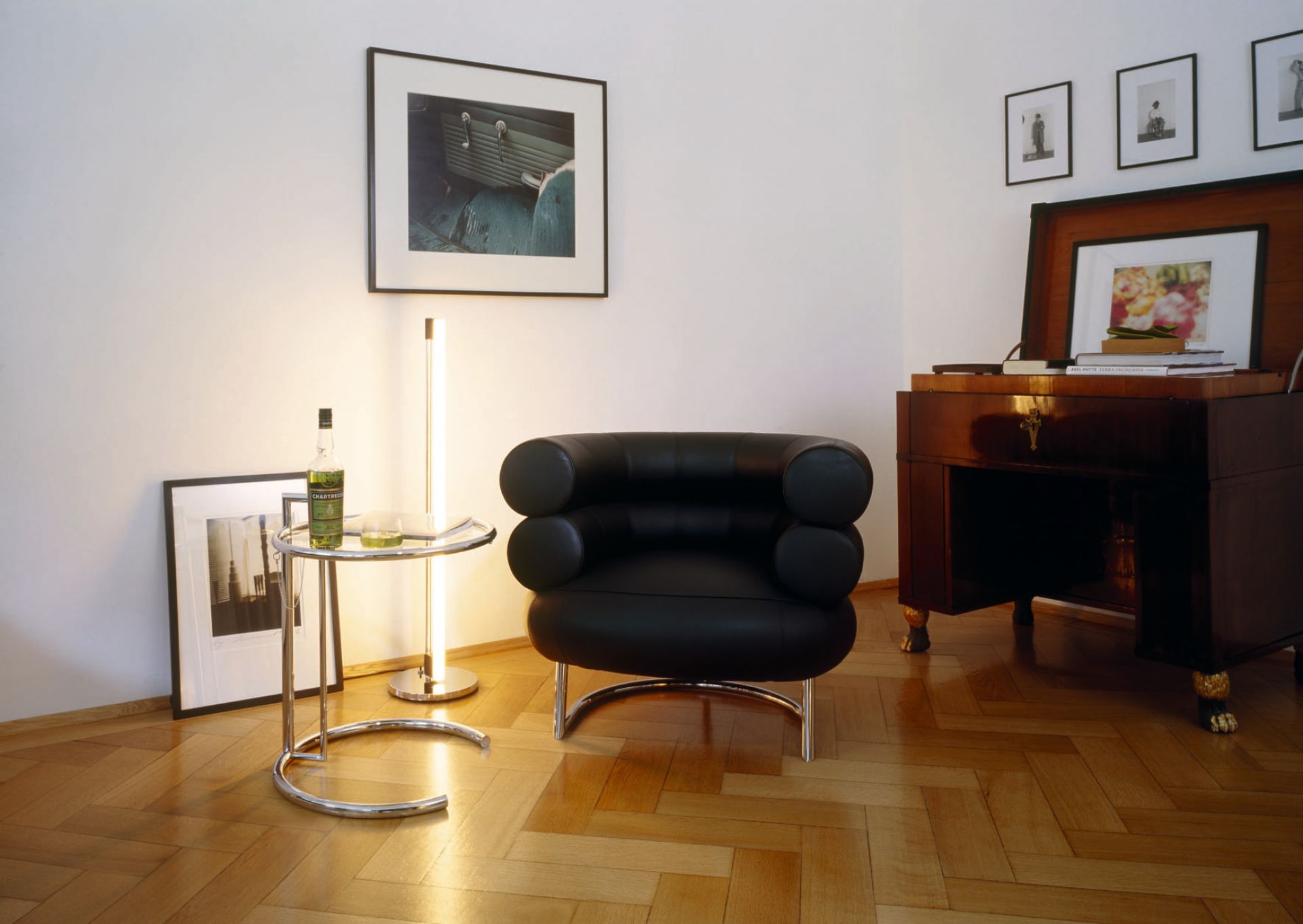Nahaufnahme des ClassiCon Adjustable Table E1027 Beistelltisch mit Glasplatte und verchromtem Gestell in modernem Interieur.