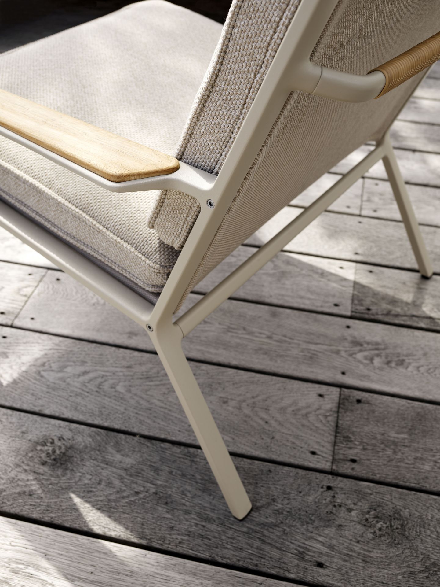 Detailaufnahme des Vipp Open-Air Lounge Stuhls mit Holzarmlehne und bequemen Outdoor-Kissen.