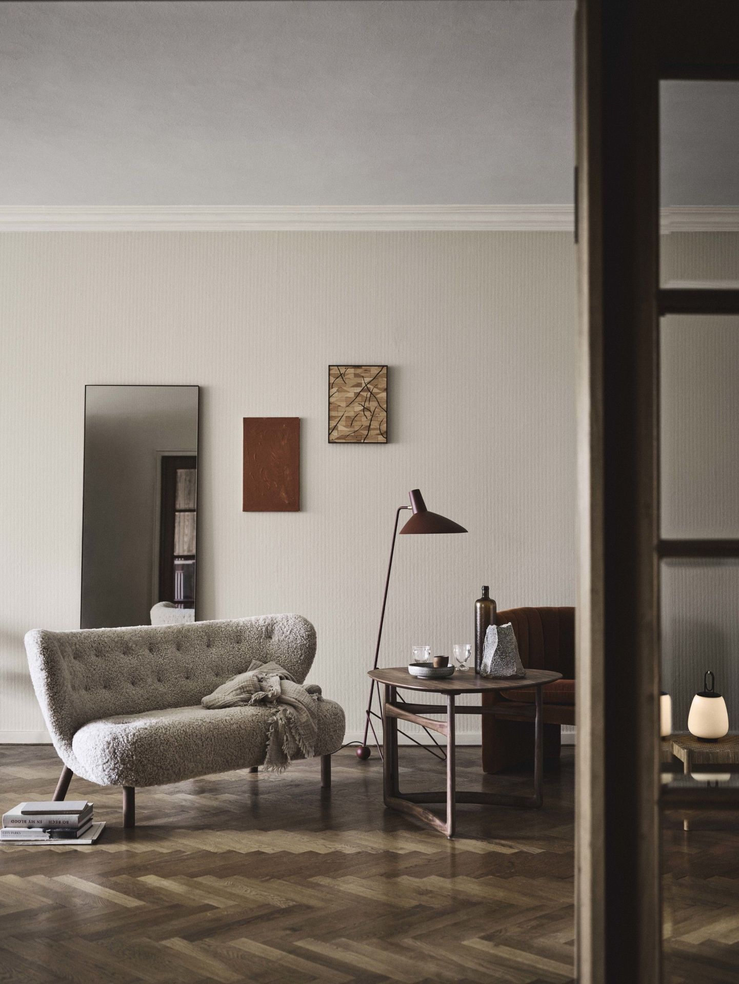 Wohnzimmer mit AndTradition Beistelltisch Drop Leaf HM5, Lampe, Sofa und Deko auf Parkettboden.