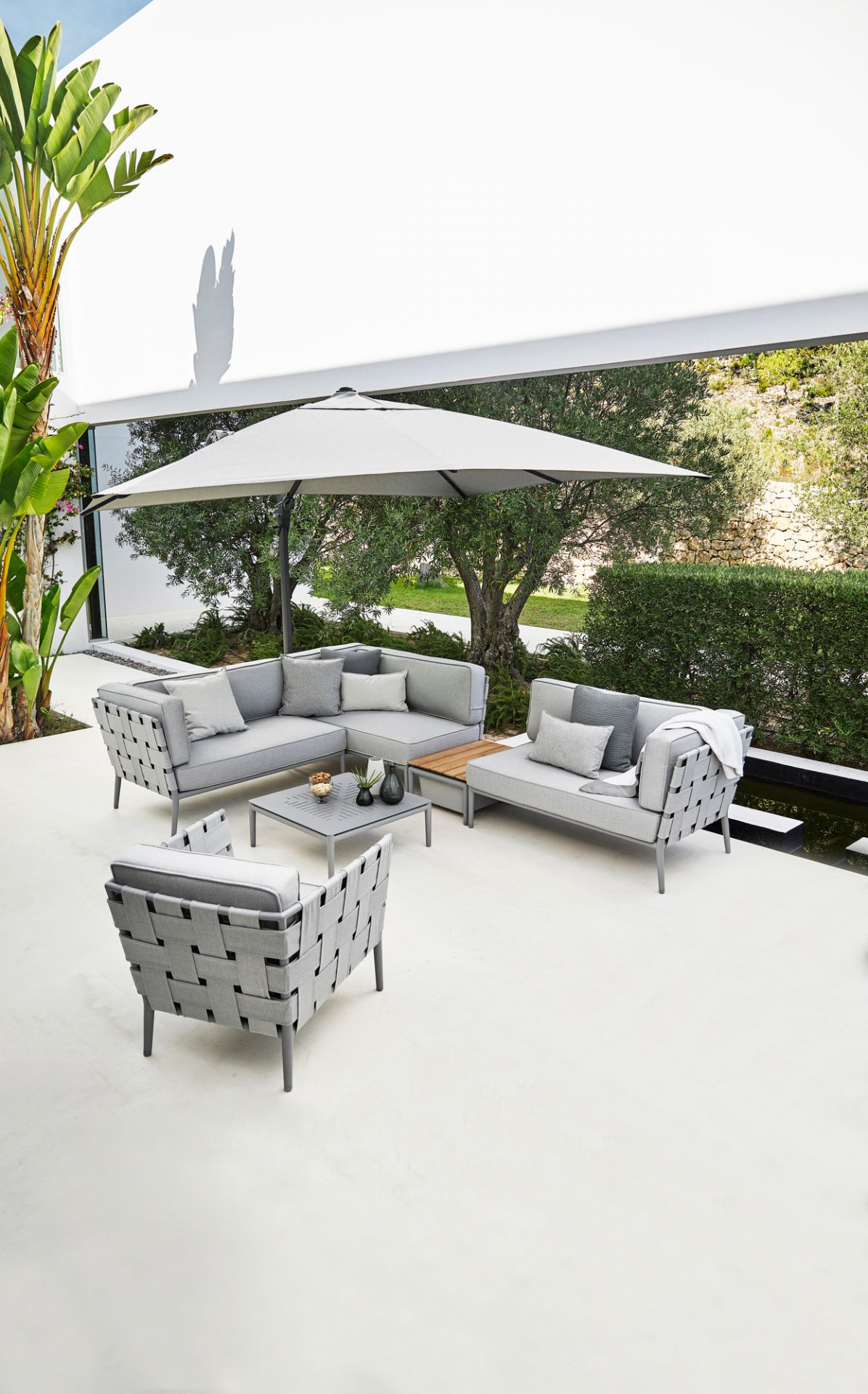 Helles Conic AirTouch Outdoor Lounge Set von Cane-Line mit Sofa, Sessel und Tisch.