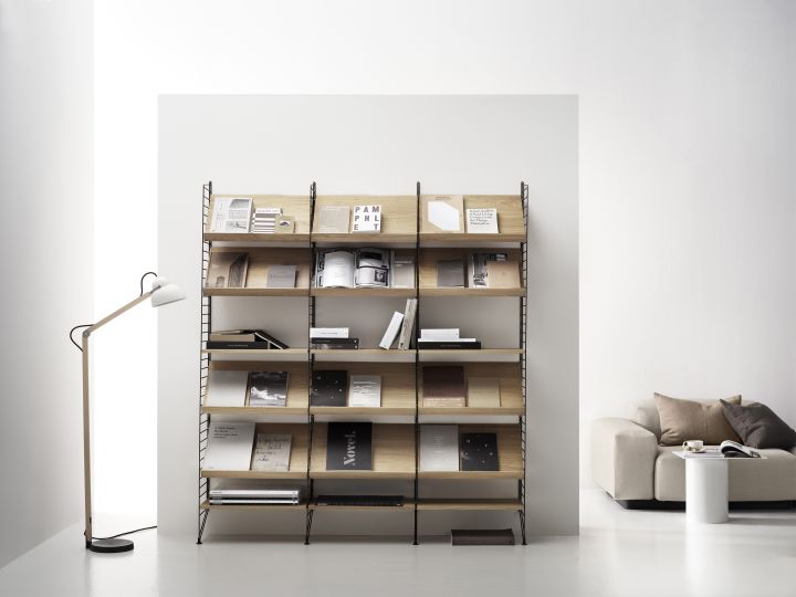 Nahaufnahme eines String Furniture Regalsystems mit Eiche-Holzablagen, ideal für Zeitschriften und Bücher.