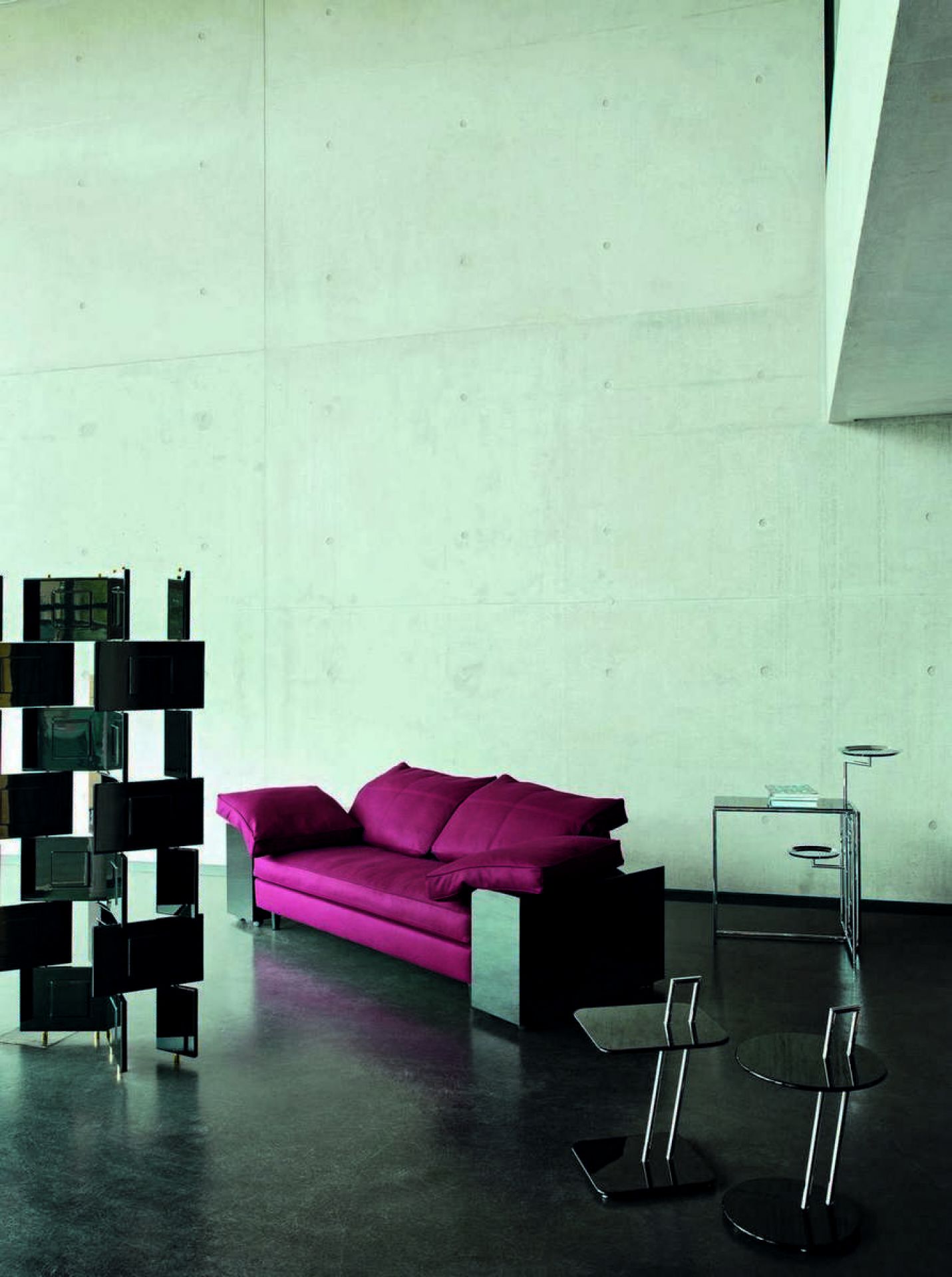 Moderner Wohnraum mit ClassiCon Beistelltischen, roten Sofa und Raumteiler. Design Möbel für stilvolles Wohnen.