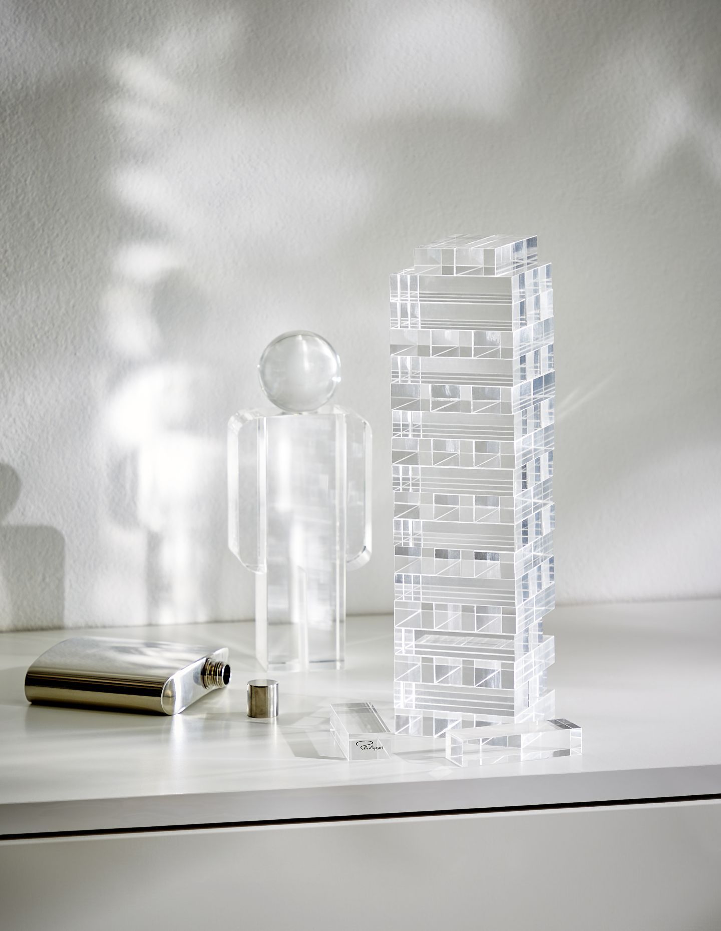Yap Geschicklichkeitsspiel von Philippi: Turm aus Acrylglas, Figur mit Glaskopf und Edelstahl-Flachmann auf weißem Untergrund.