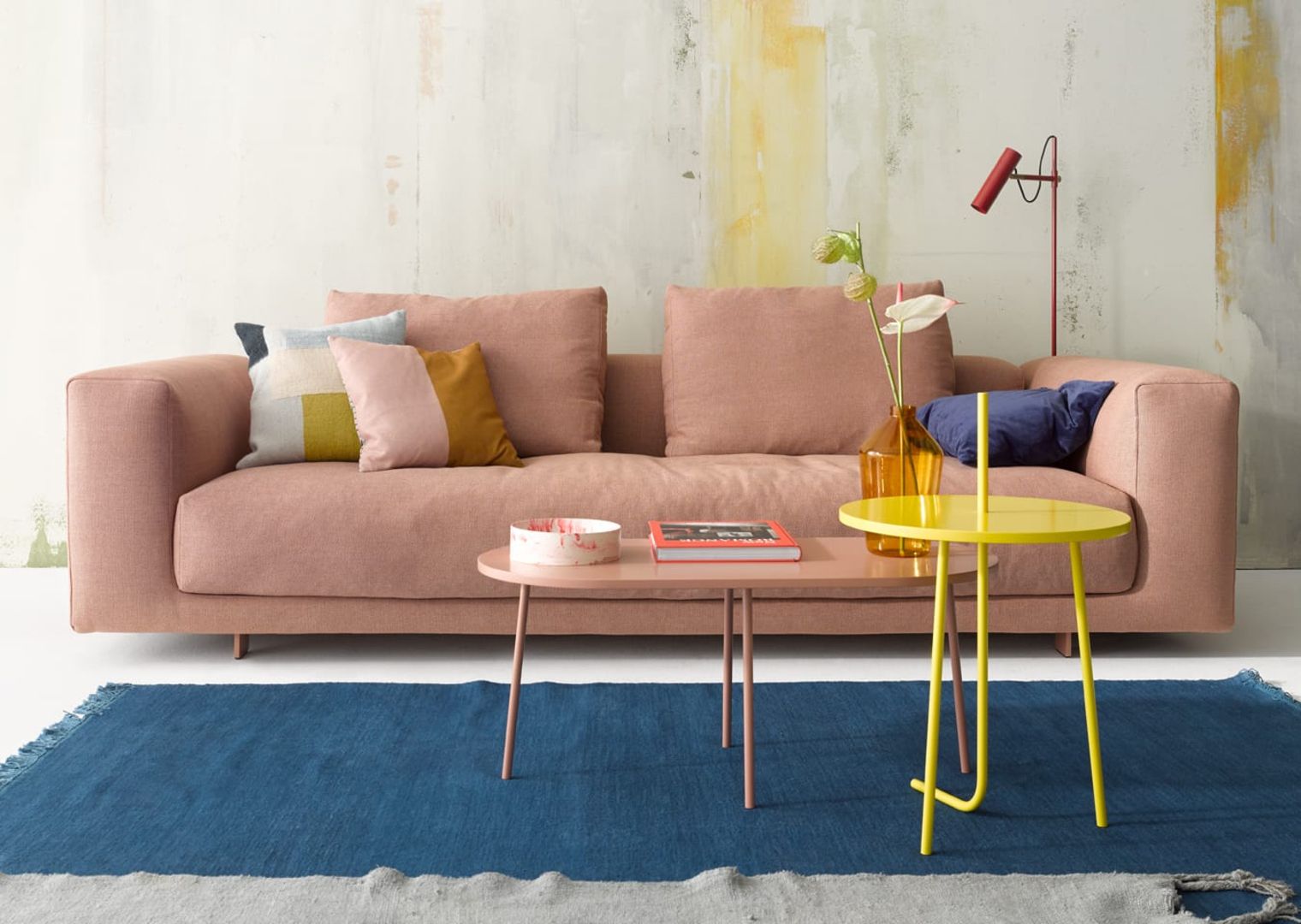 Gelber Bond Beistelltisch rund von Cor neben rosa Sofa und Teppich im Wohnzimmer.