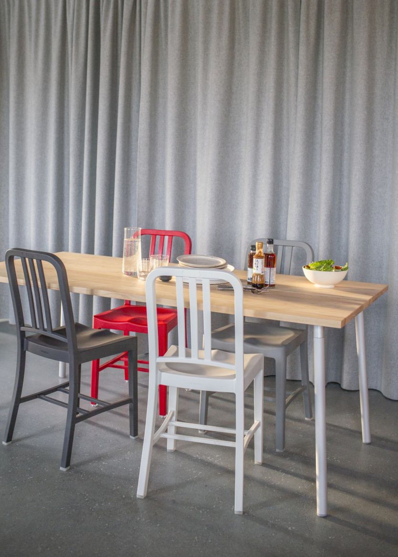 Esstisch mit vier Stühlen, darunter ein roter Emeco 111 Navy Chair Stuhl. Designermöbel für Esszimmer.