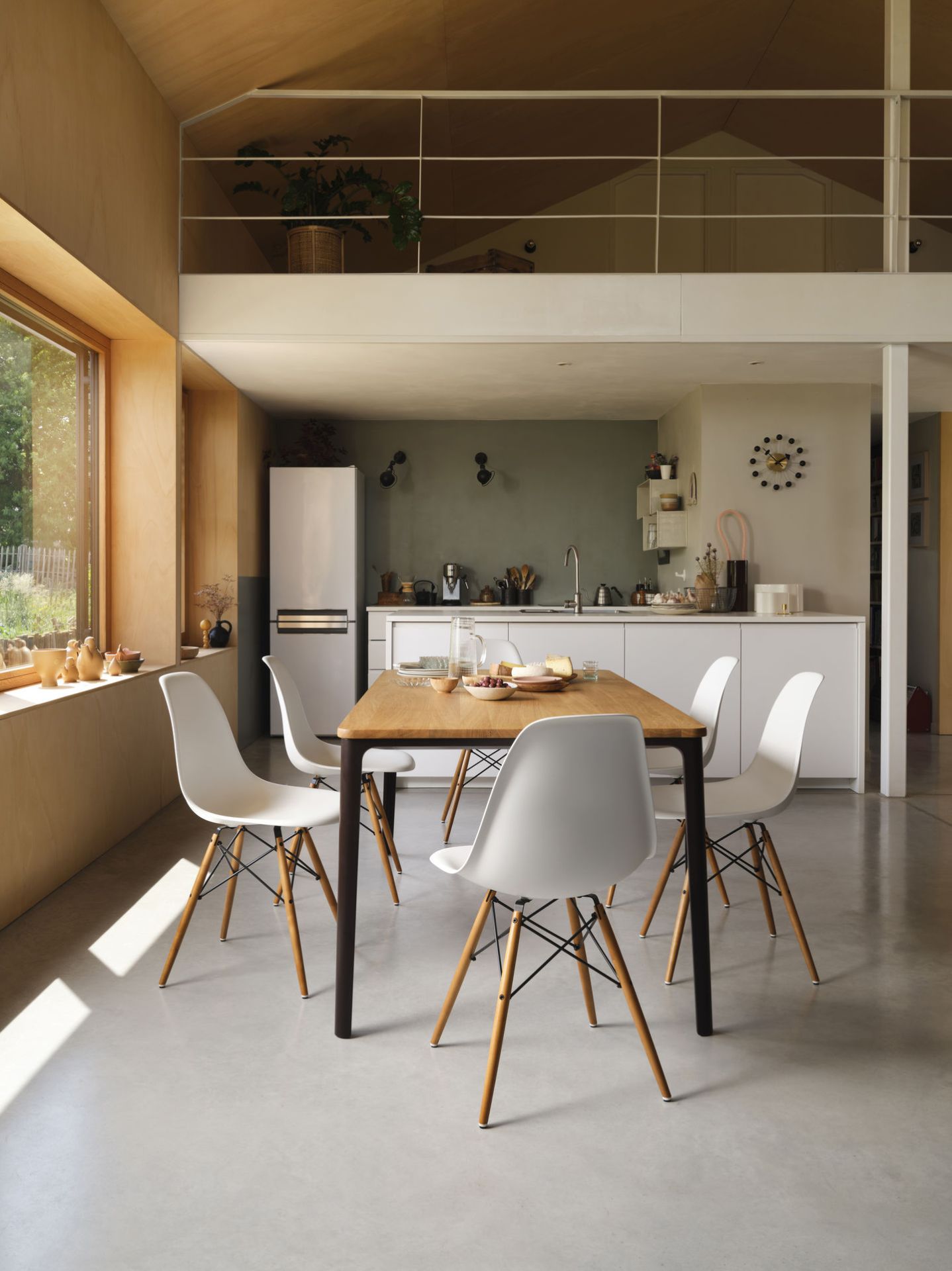Esszimmer mit Holztisch und vier weißen Eames Plastic Side Chairs DSW Stühlen von Vitra.