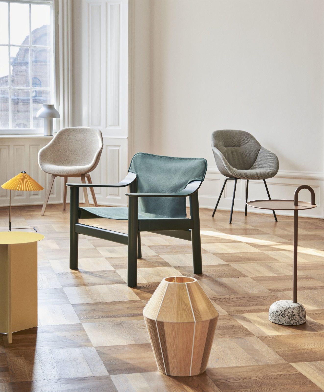 Helles Interieur mit Hay Bowler Beistelltisch in Braun, ergänzt durch moderne Stühle und dekorative Elemente.