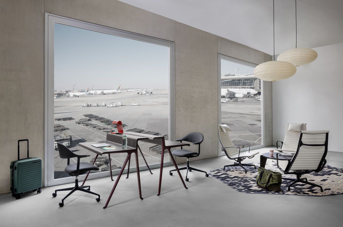 Helles Büro mit Vitra Aluminium Chair EA 125 und EA 125 Hocker vor großem Fenster.