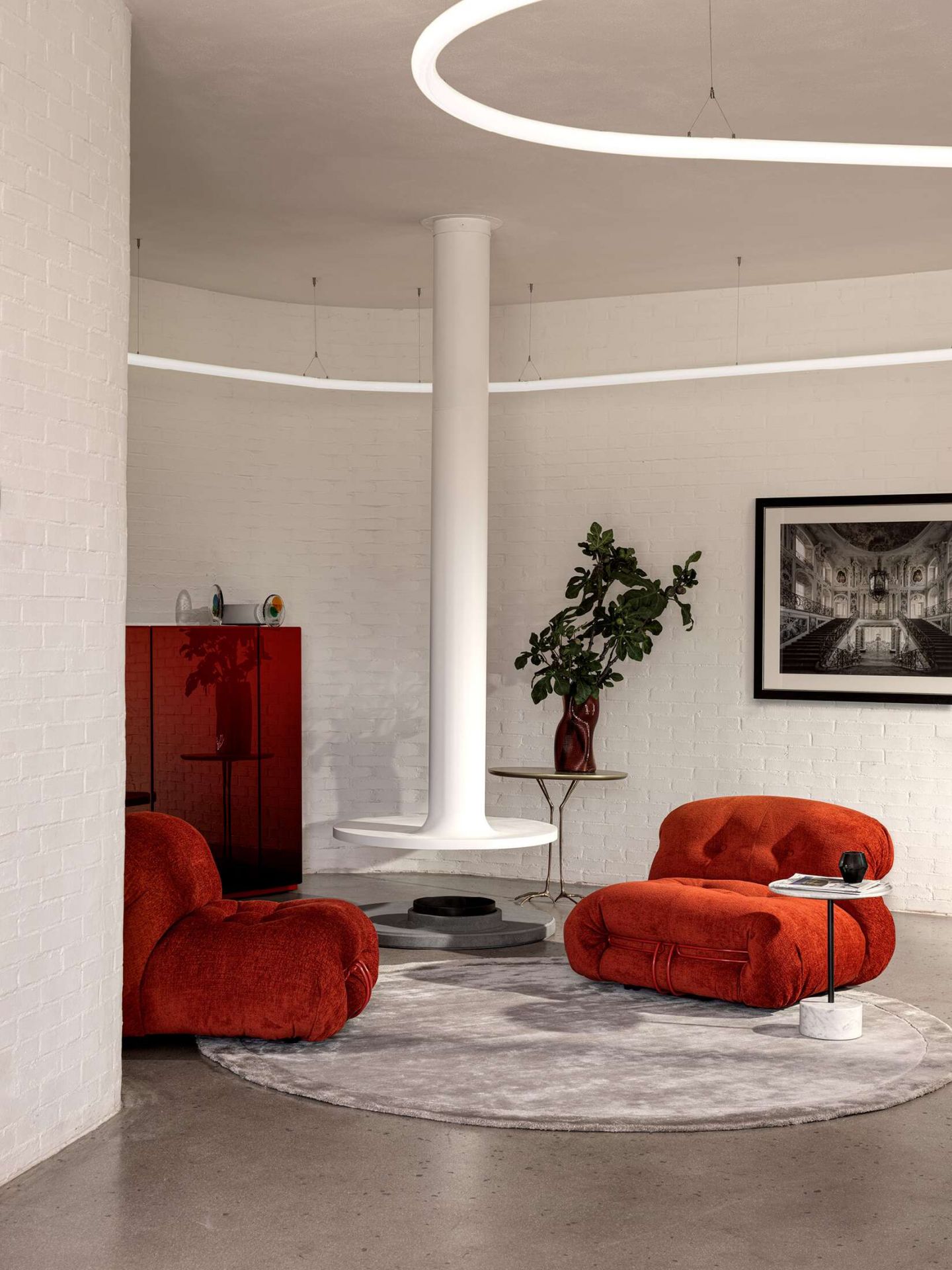 Zwei rote Soriana Sessel von Cassina in einem modernen Wohnzimmer mit weißem Kamin.