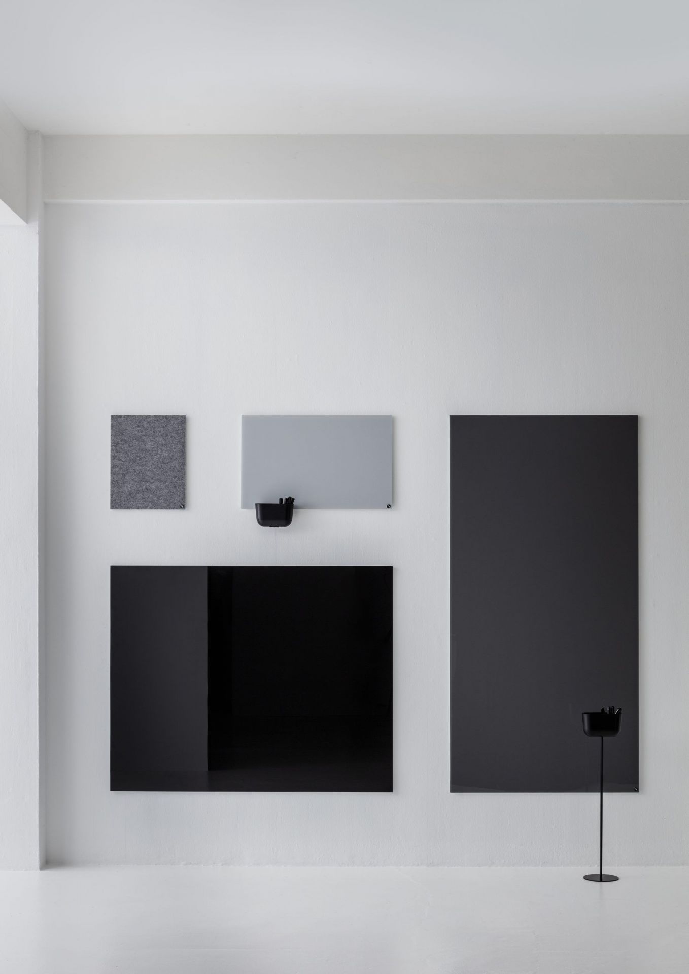 Wand mit grauer Filztafel und Chat Board Classic Glastafeln in Schwarz und Grau mit Stifthalter.